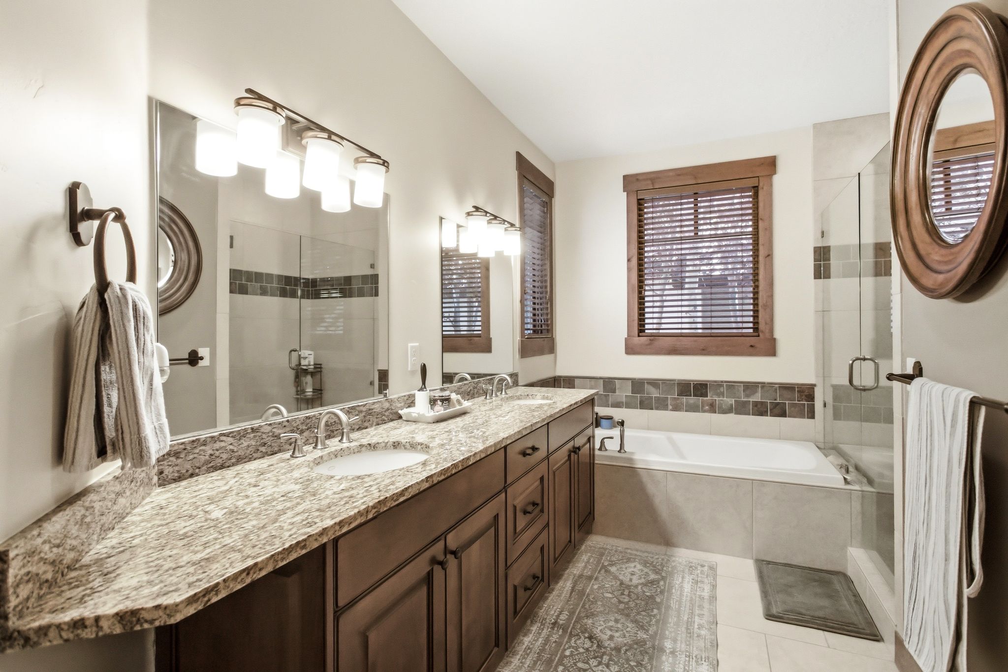 Bathroom featuring a double vanity with granite countertops, wood-finish cabinetry, and undermount sinks