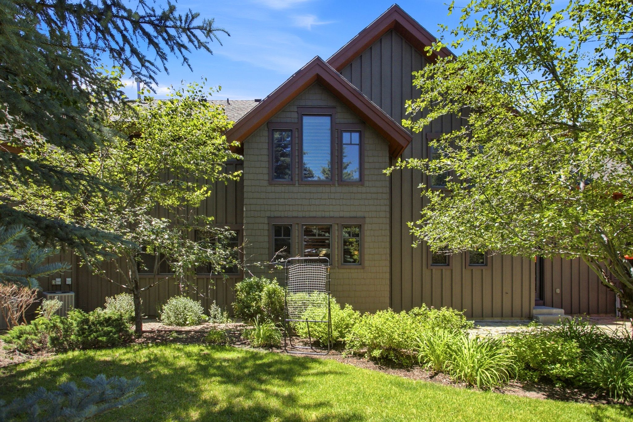 Exterior featuring vertical board siding and shake siding accents