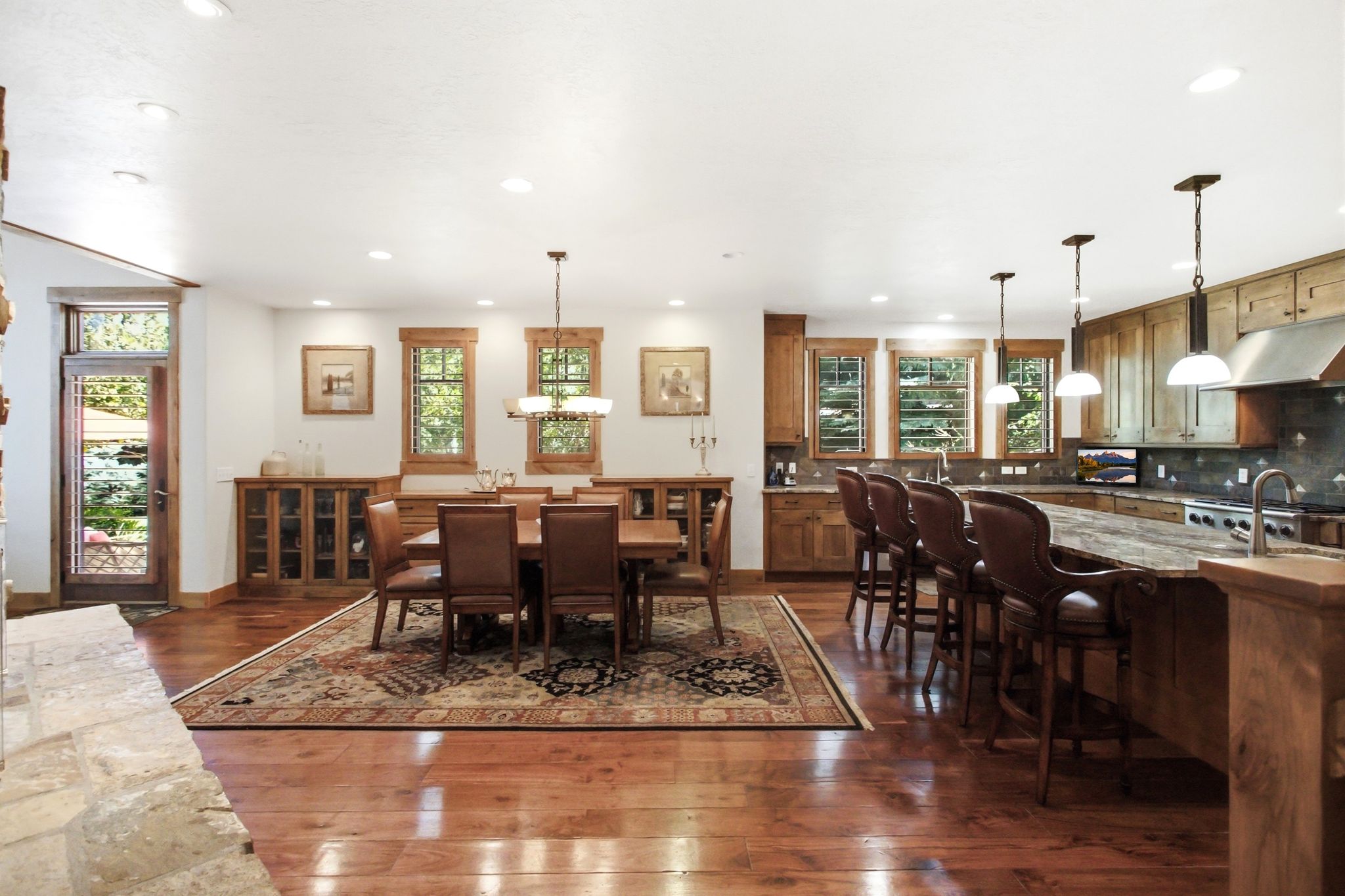 Open-concept kitchen and dining area featuring wood-finish flooring, recessed lighting, and wooden cabinetry