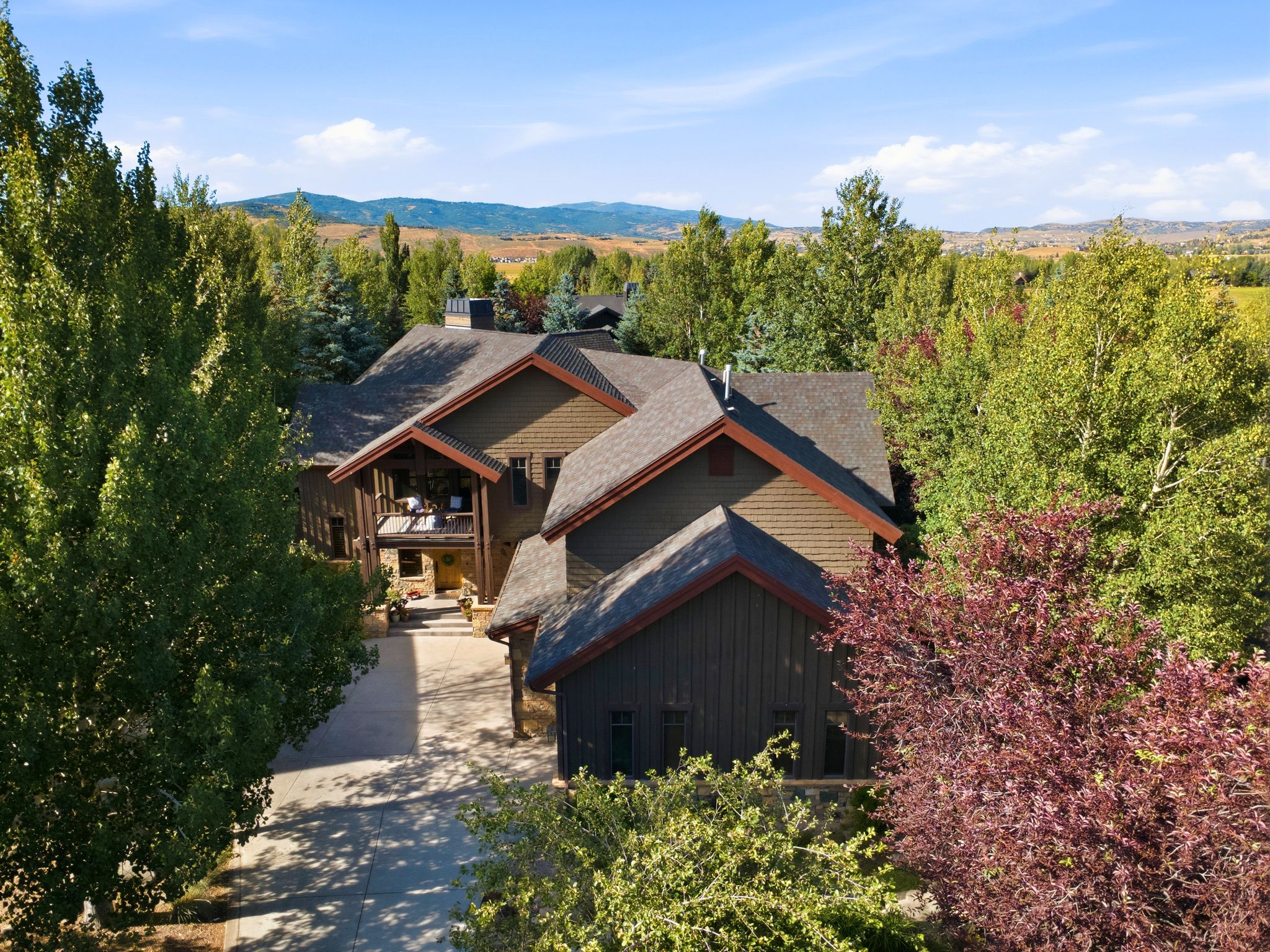 Expansive property featuring a multi-level residence with a wood-shingle exterior and dark trim
