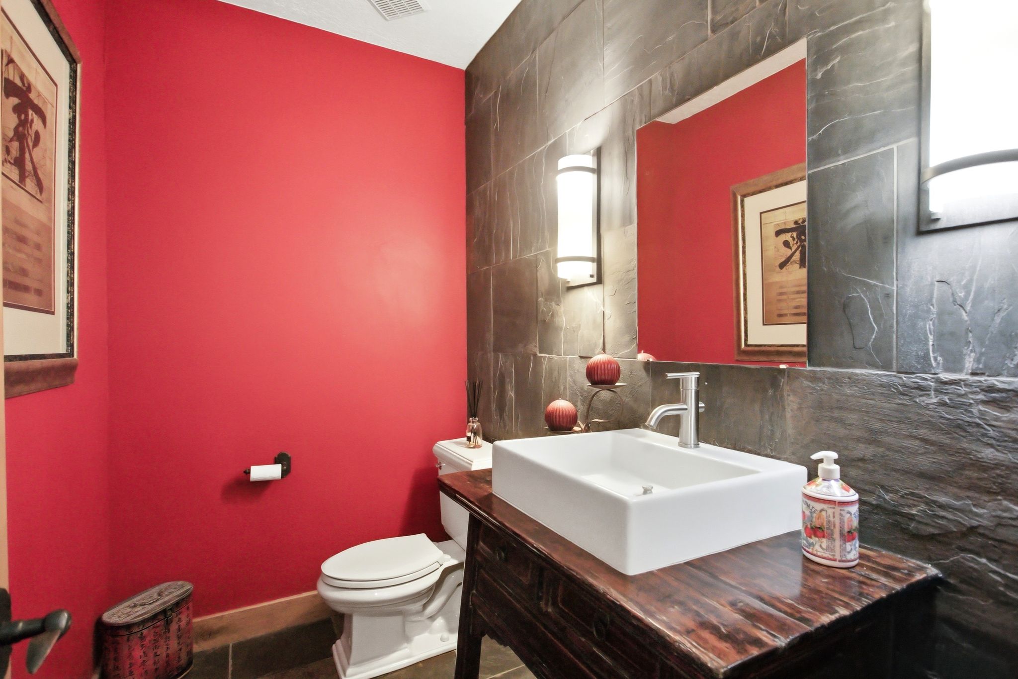 Bathroom featuring a rectangular vessel sink, polished chrome faucet, and a distressed wood-finish vanity