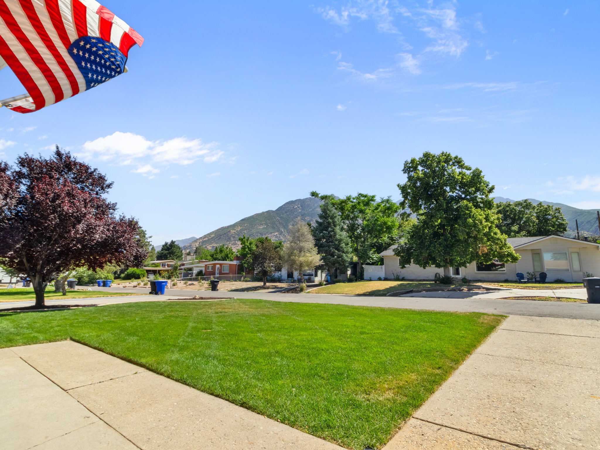 Expansive green lawn with a sidewalk and mountain backdrop