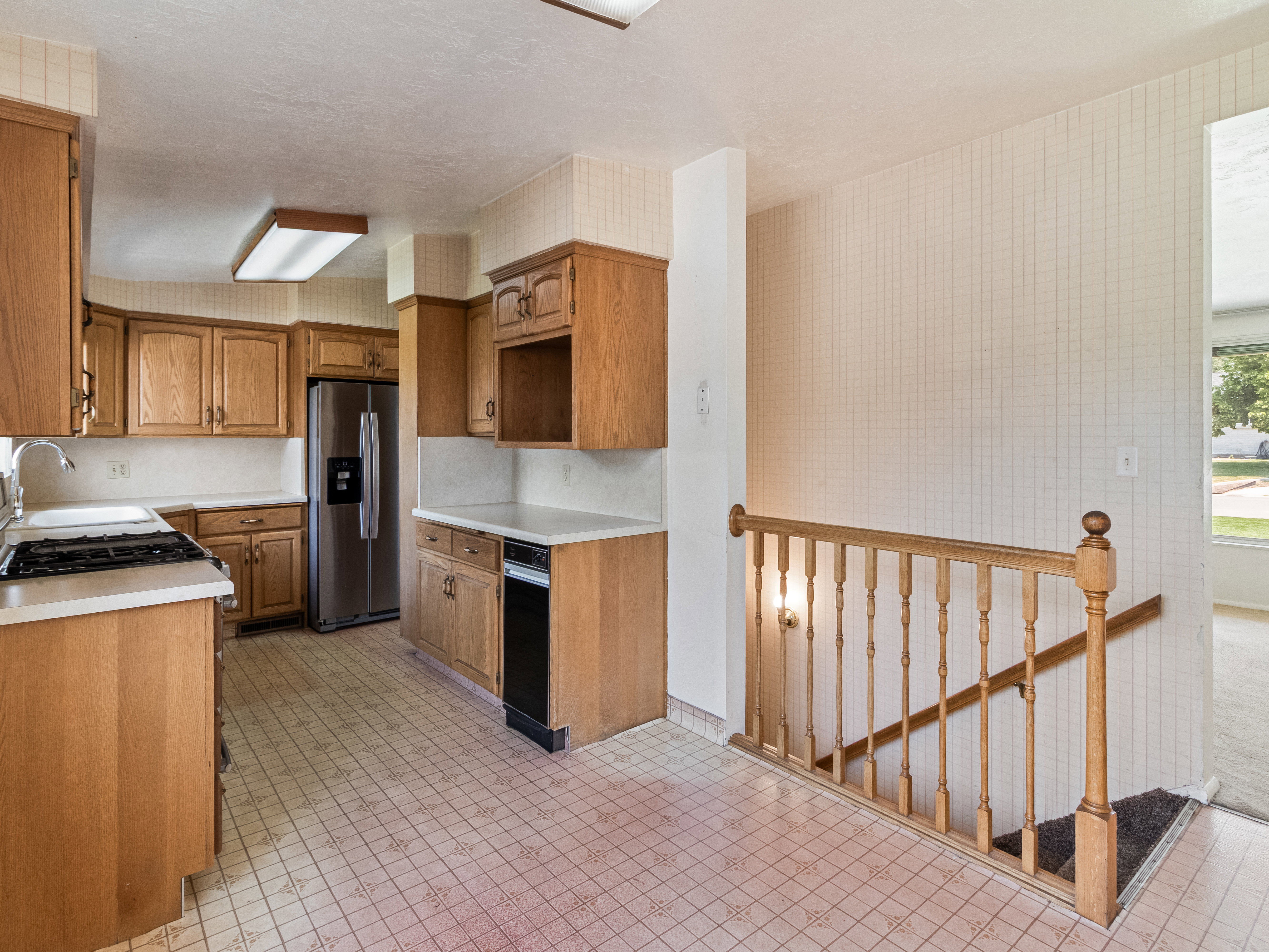 Kitchen featuring wood cabinetry, white countertops, built-in stainless steel refrigerator, and a gas cooktop