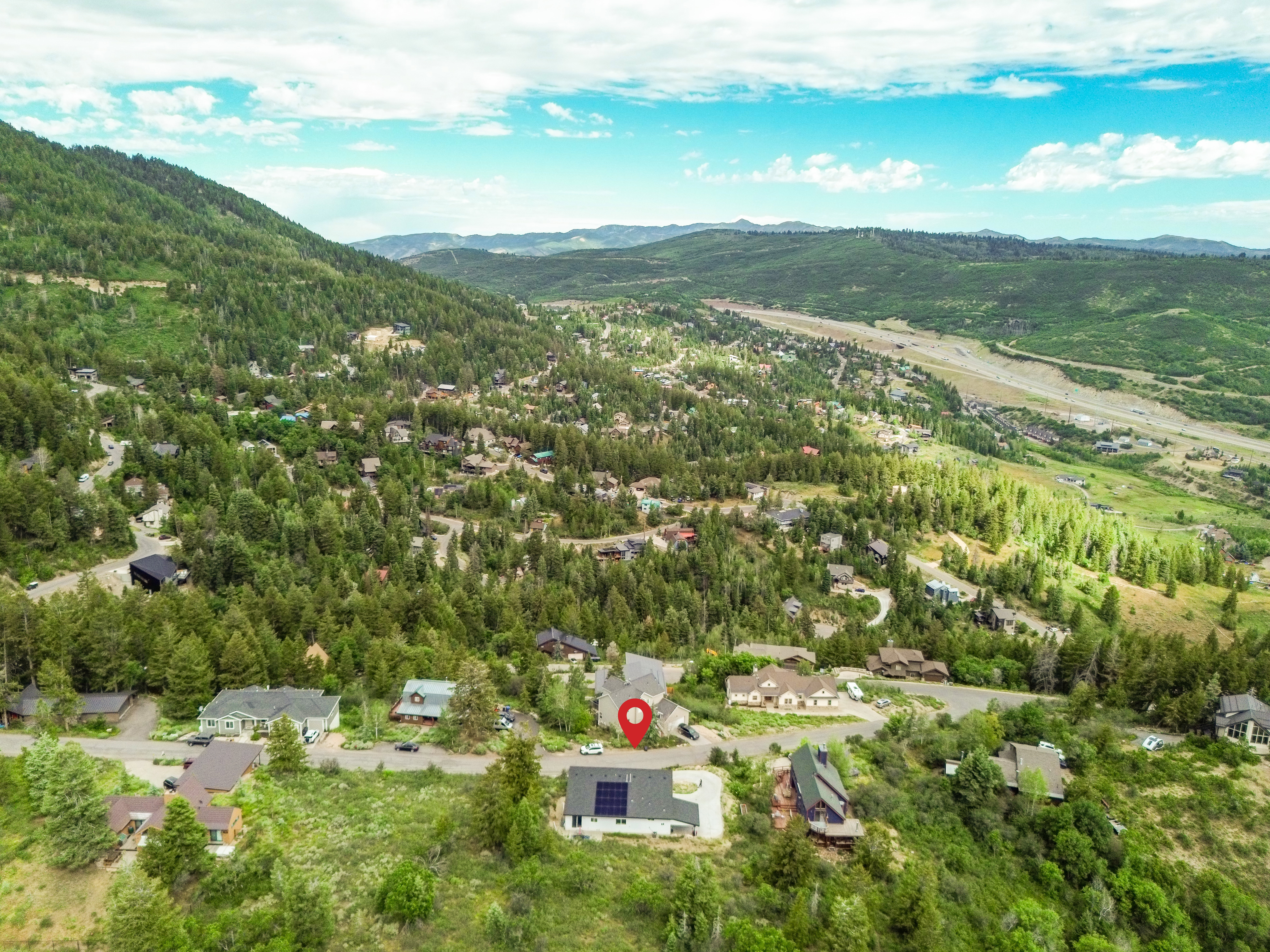 Mountainous landscape featuring residential properties and extensive tree coverage