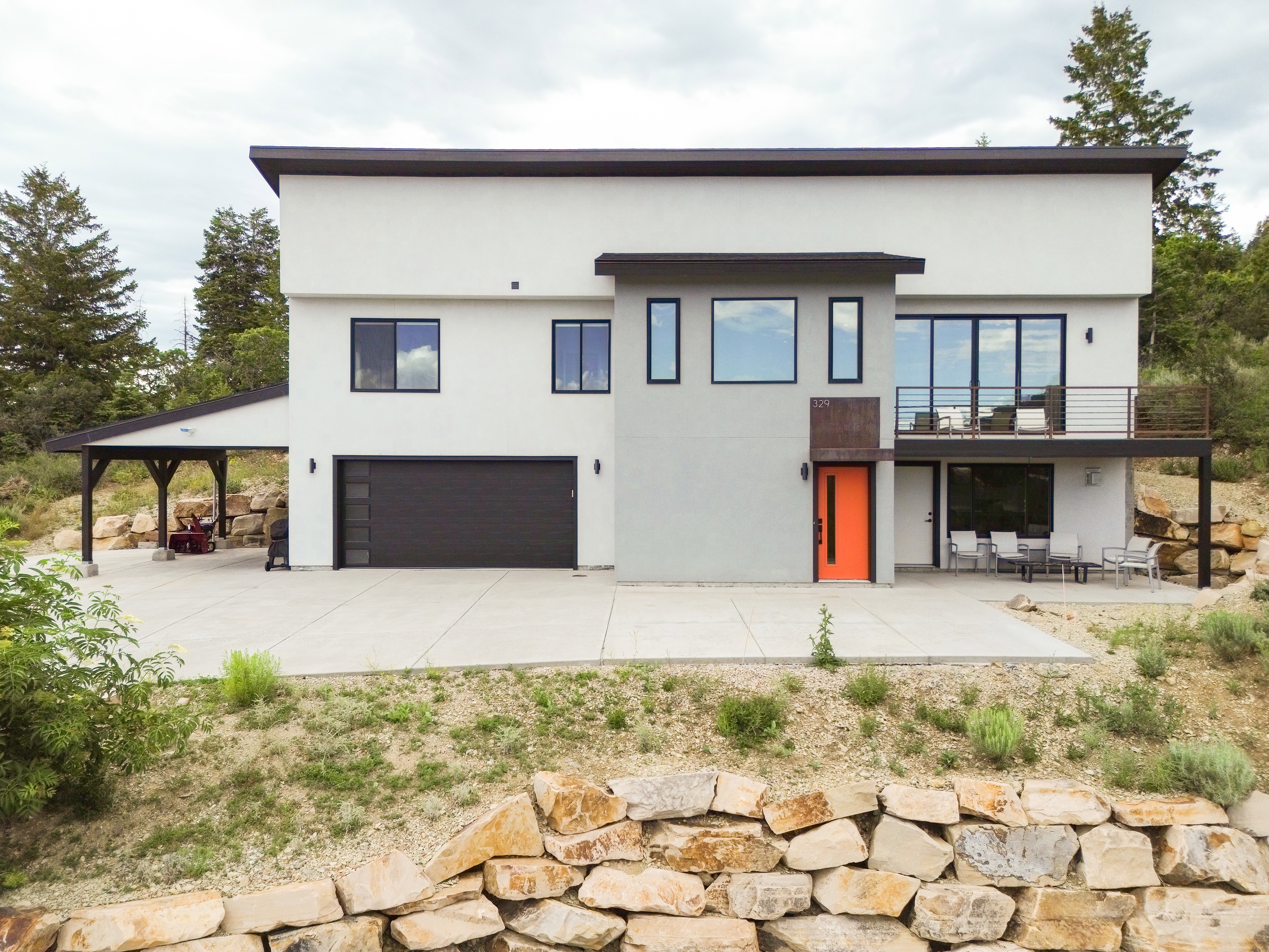Contemporary architecture with a vibrant orange entry door and black-framed windows