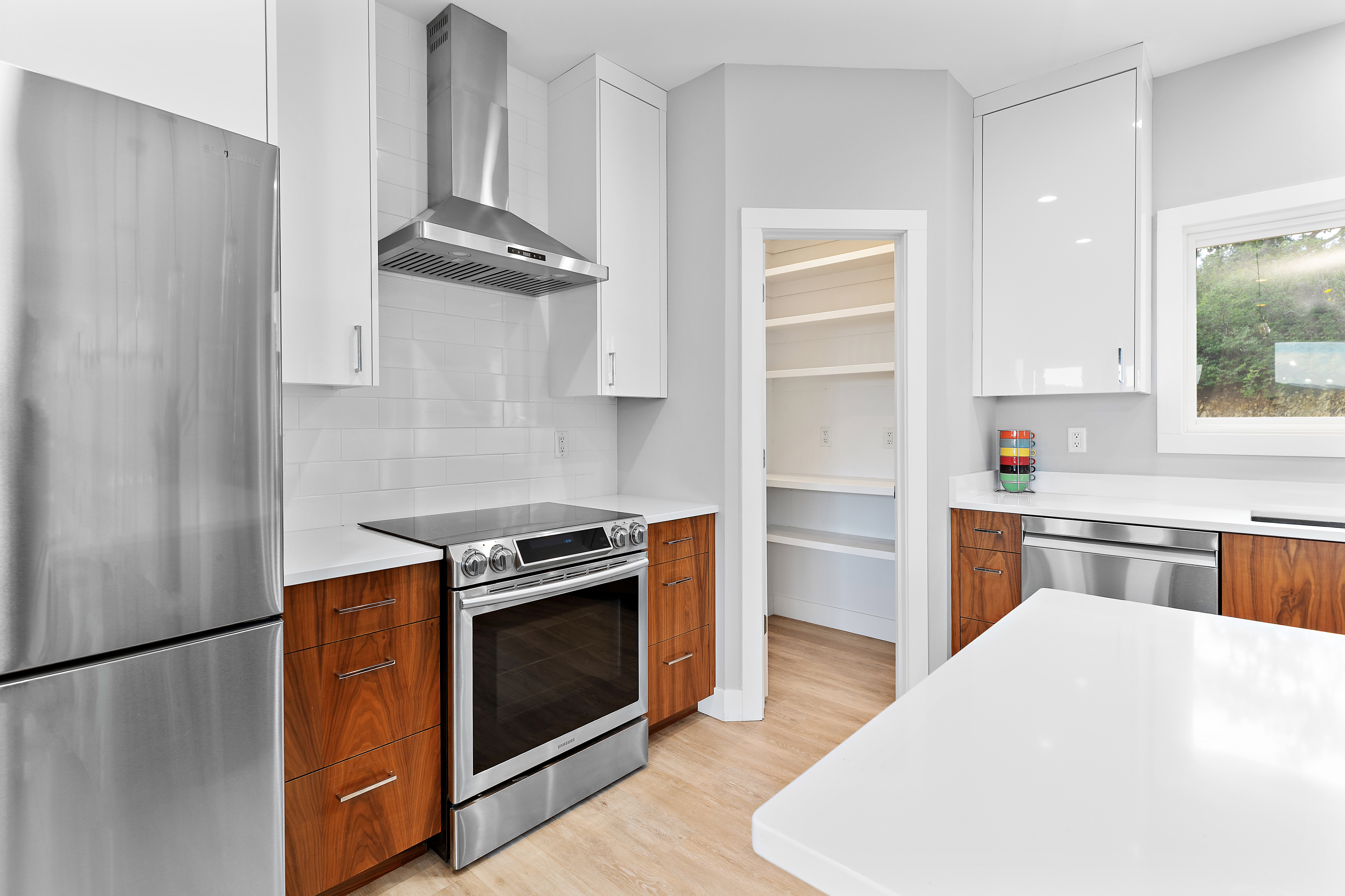 Contemporary kitchen with stainless steel appliances, including a refrigerator, range, and dishwasher