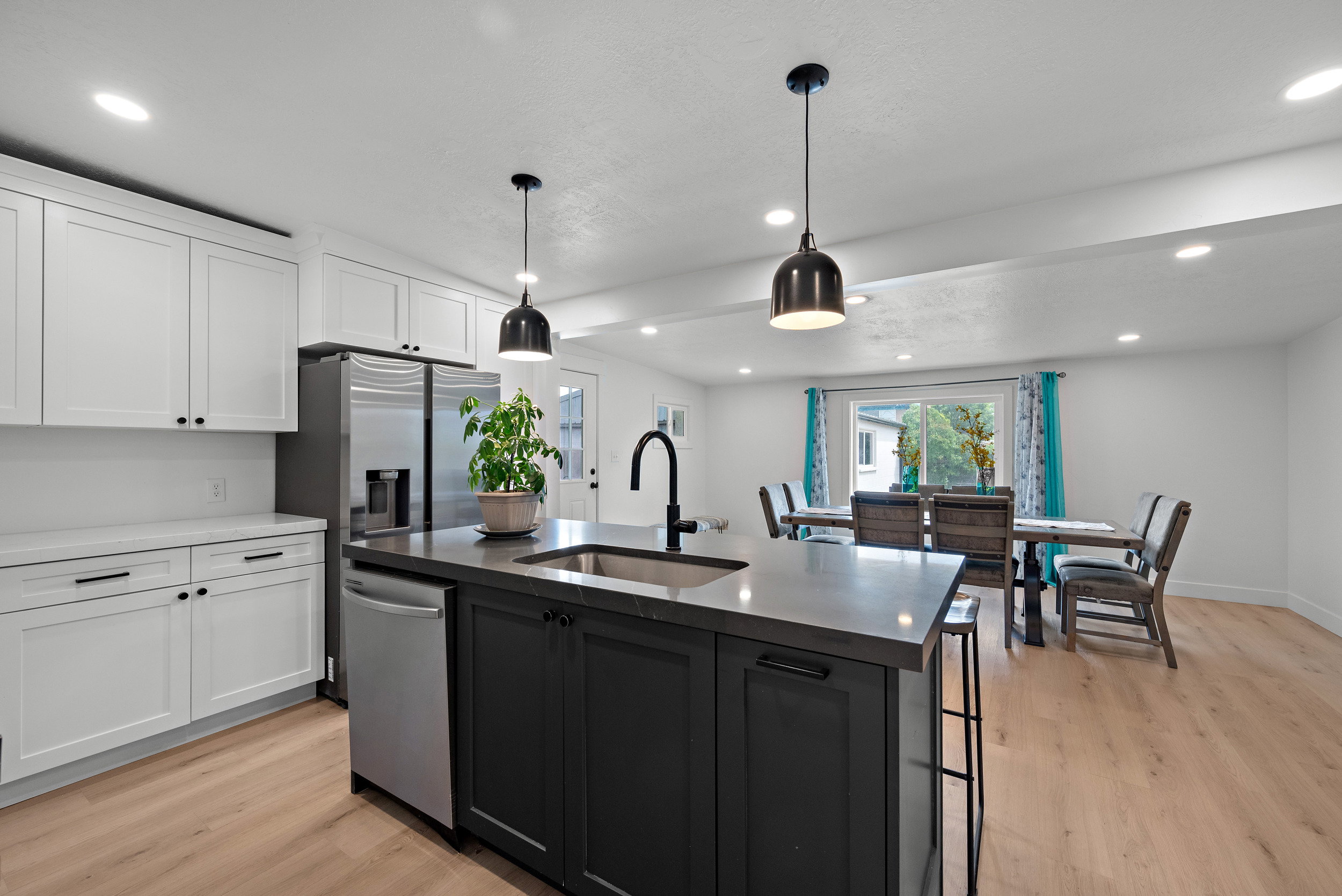 Modern kitchen featuring a central island with a sink and pendant lighting