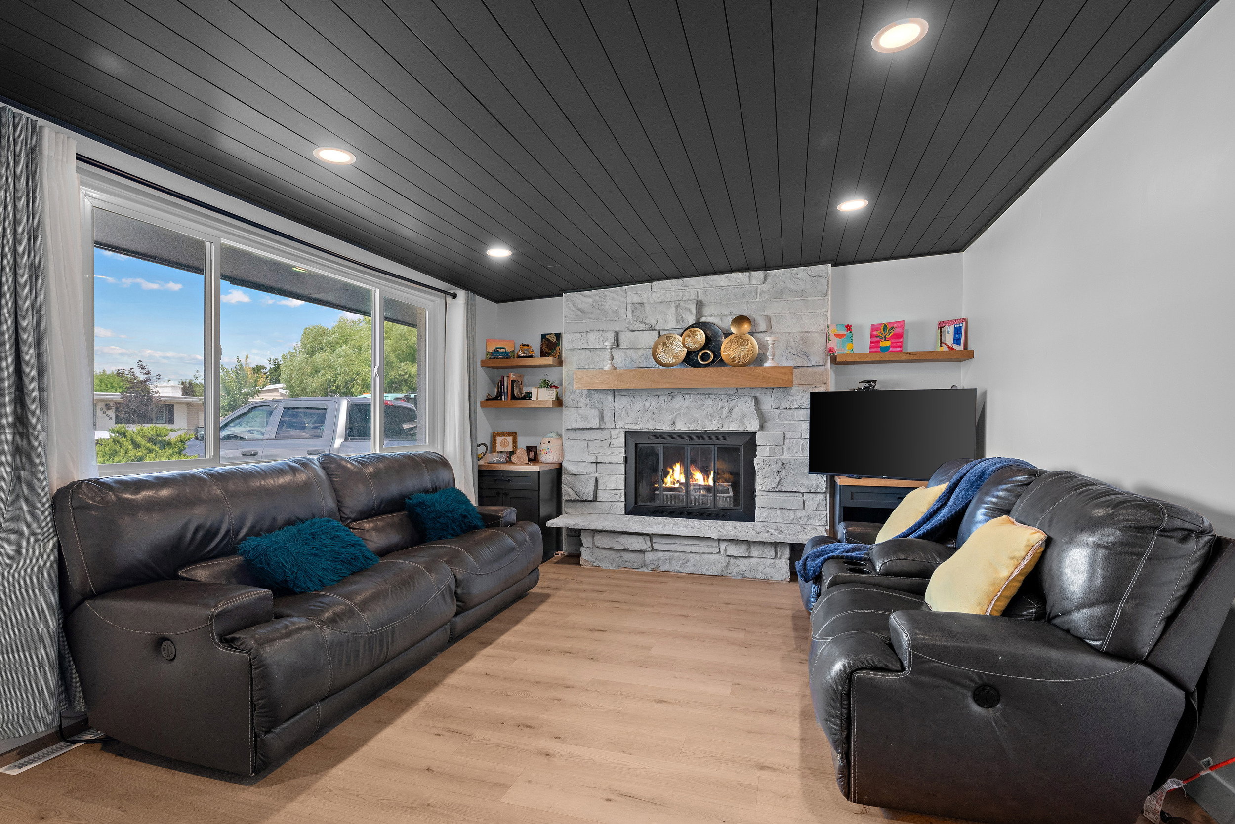 Living area featuring a stone-clad fireplace with a wood mantel