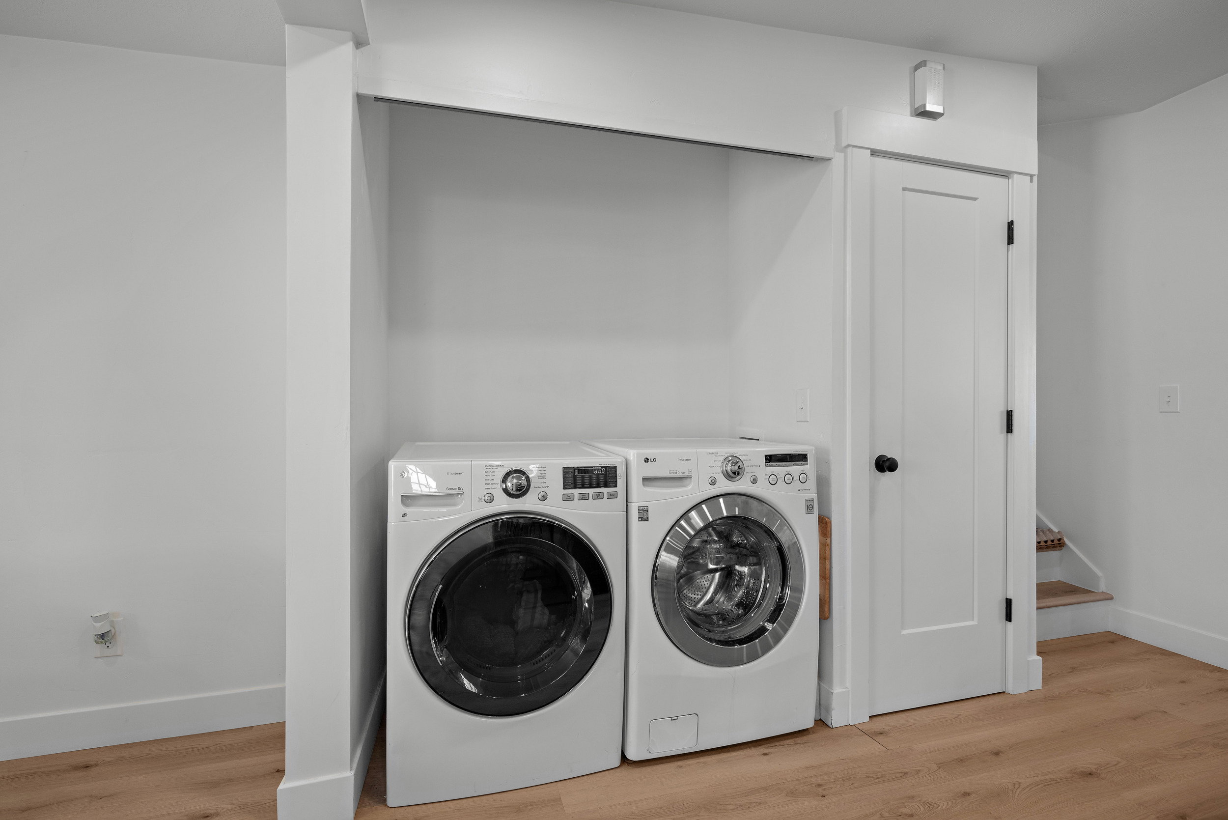 Dedicated laundry area featuring wood-finish flooring