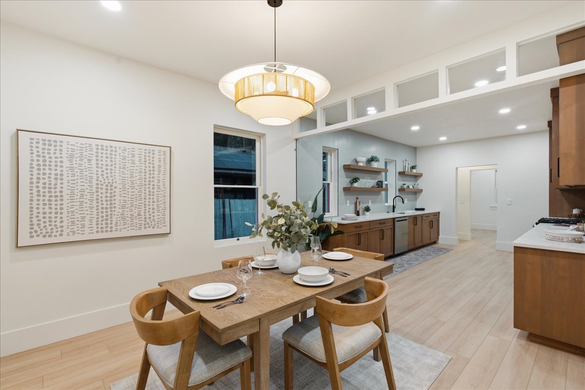 Open-concept dining and kitchen area featuring wood-finish flooring