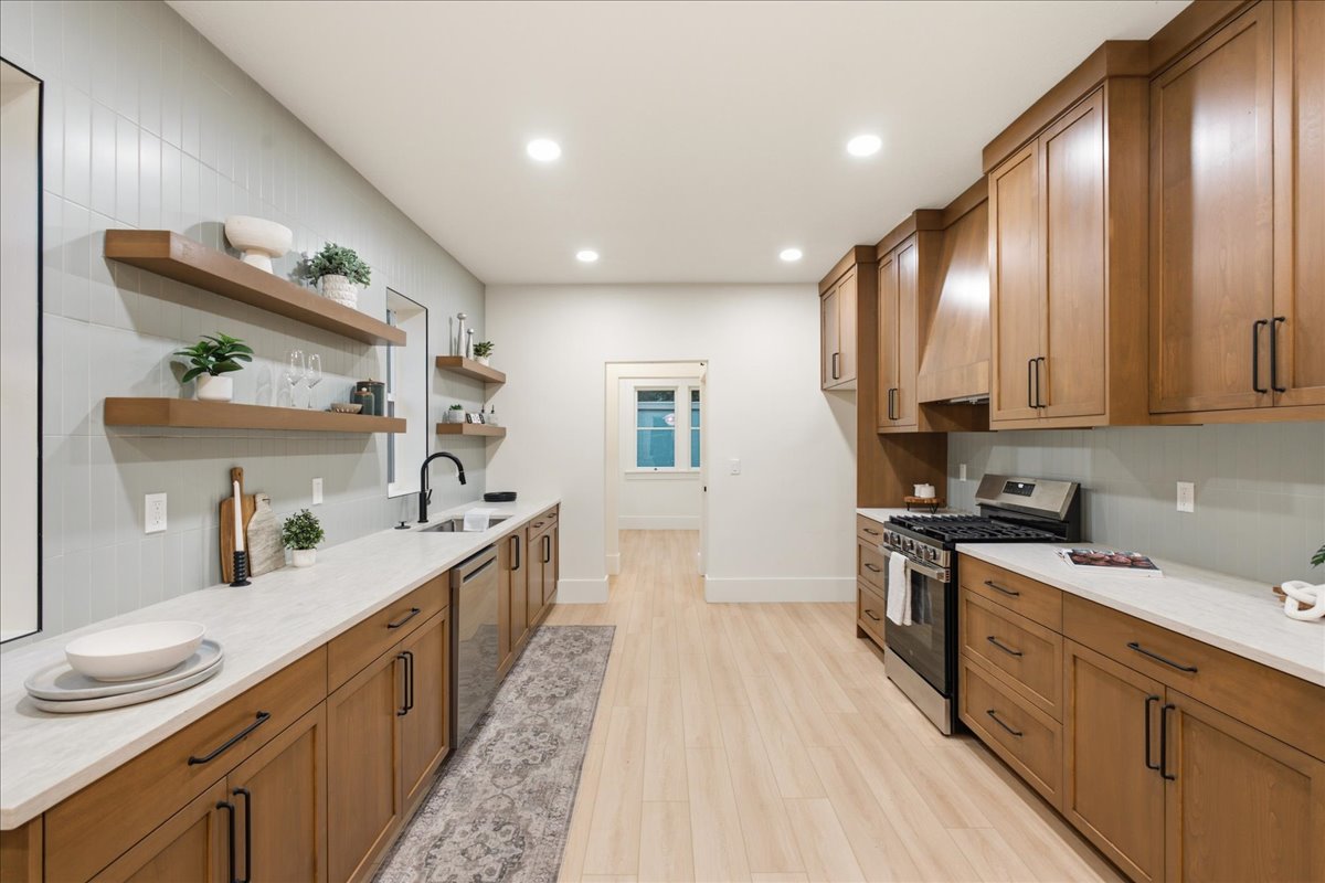 Modern kitchen featuring light wood-finish flooring, recessed lighting, and a light-toned tile backsplash