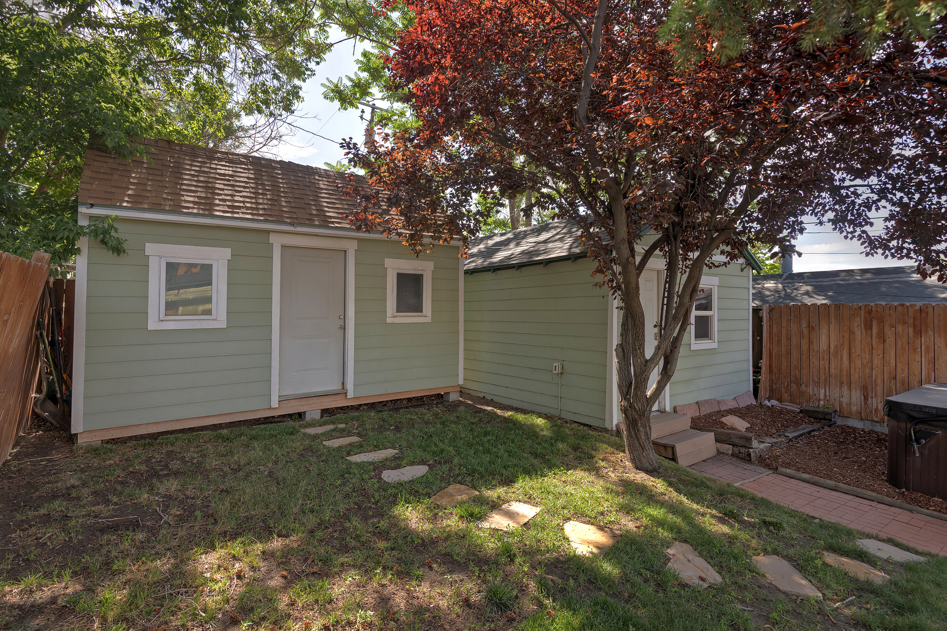 Two detached outbuildings with horizontal siding and shingle roofs