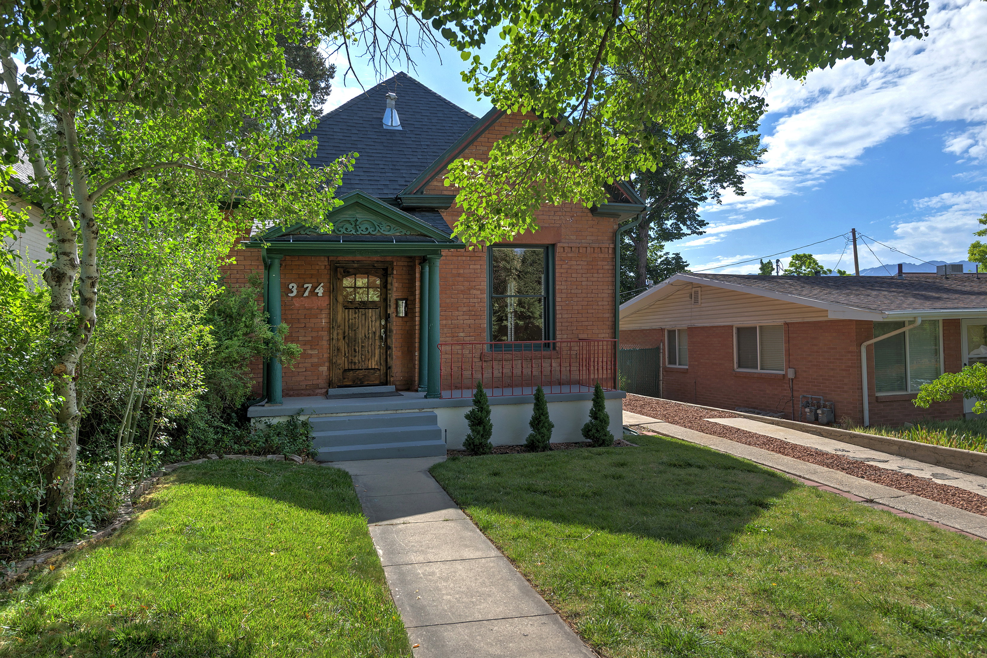 Brick exterior with dark green trim and a gabled roofline
