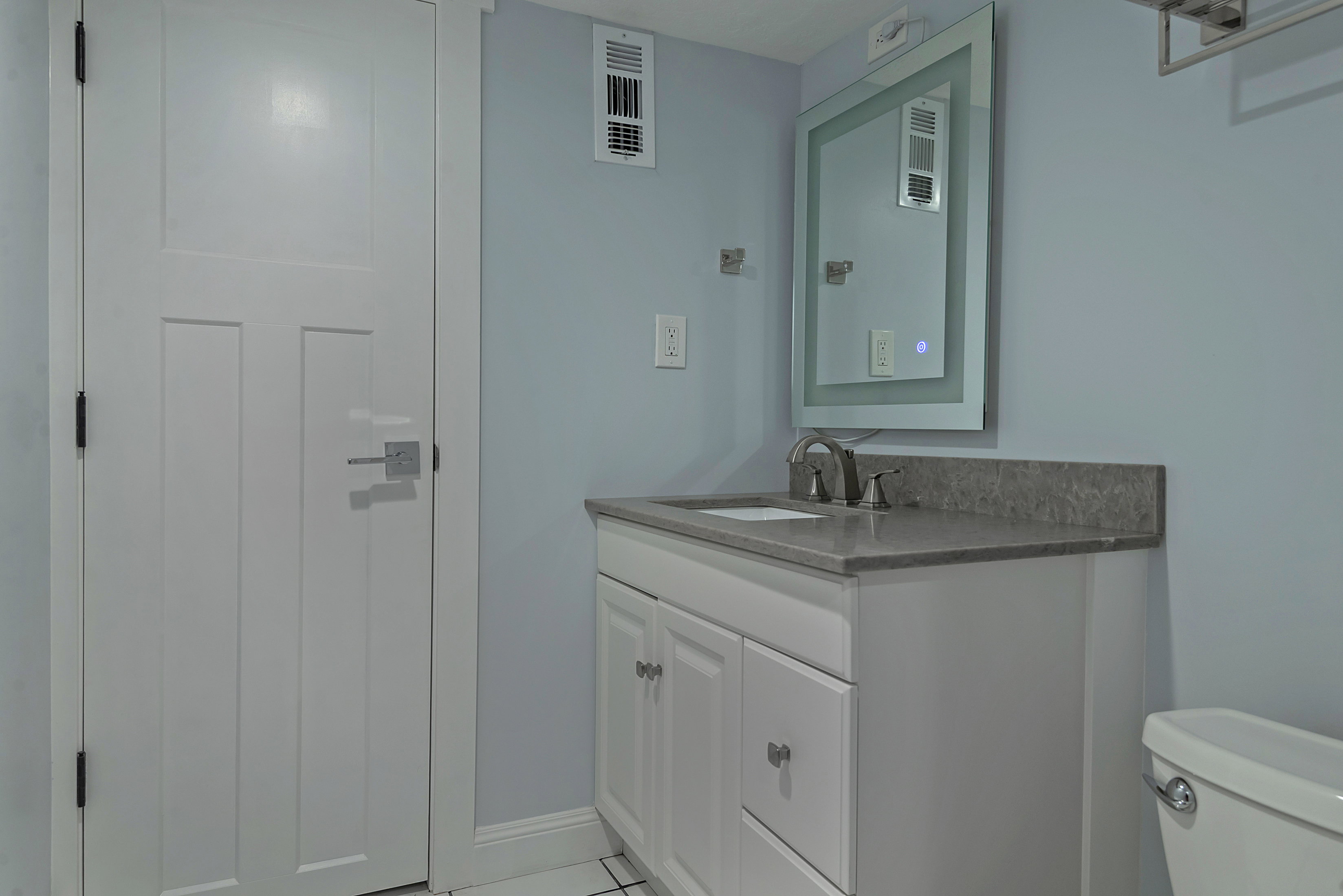 Modern bathroom vanity with a gray stone countertop and undermount sink