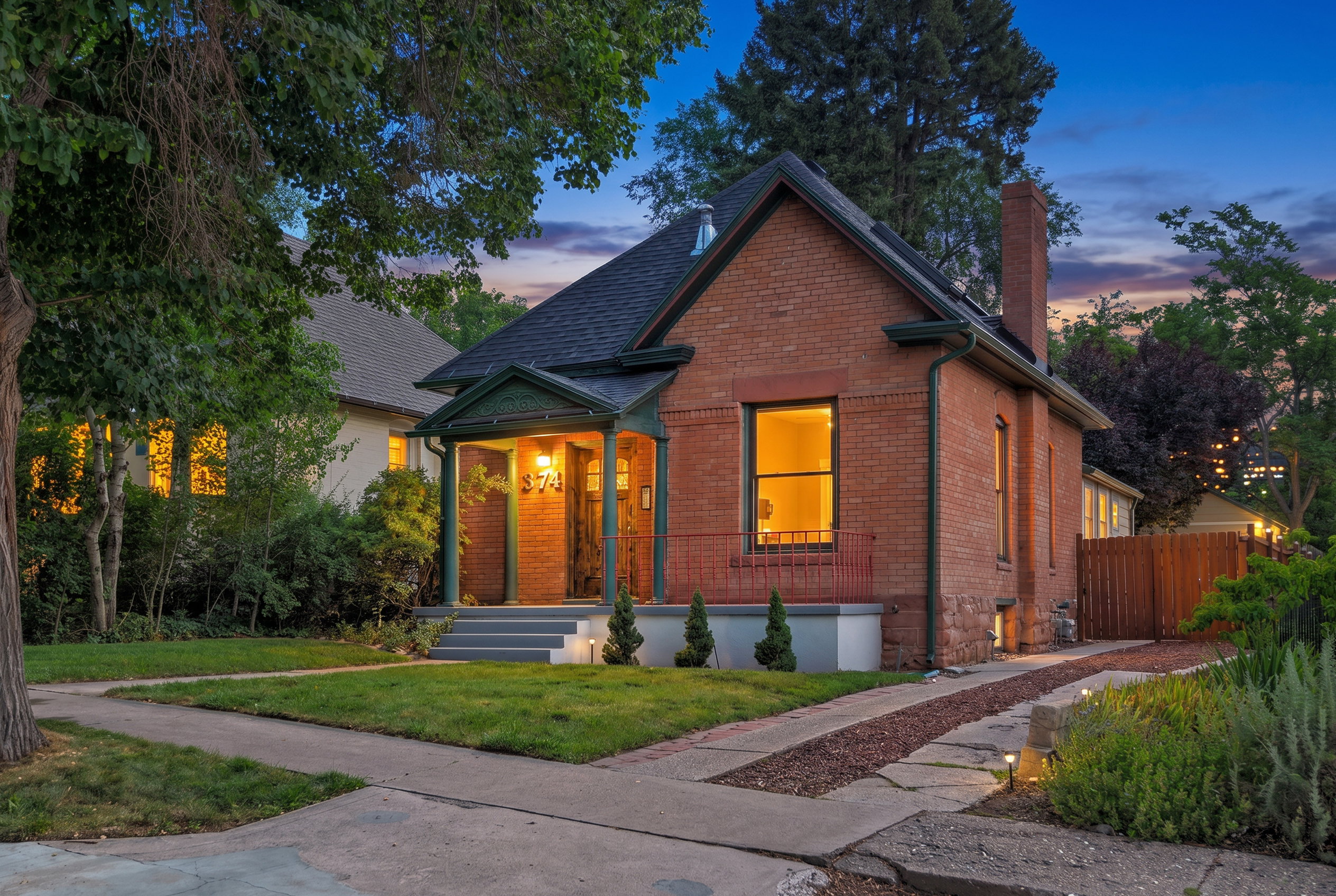 Brick exterior featuring a gabled roof and a covered porch with decorative columns