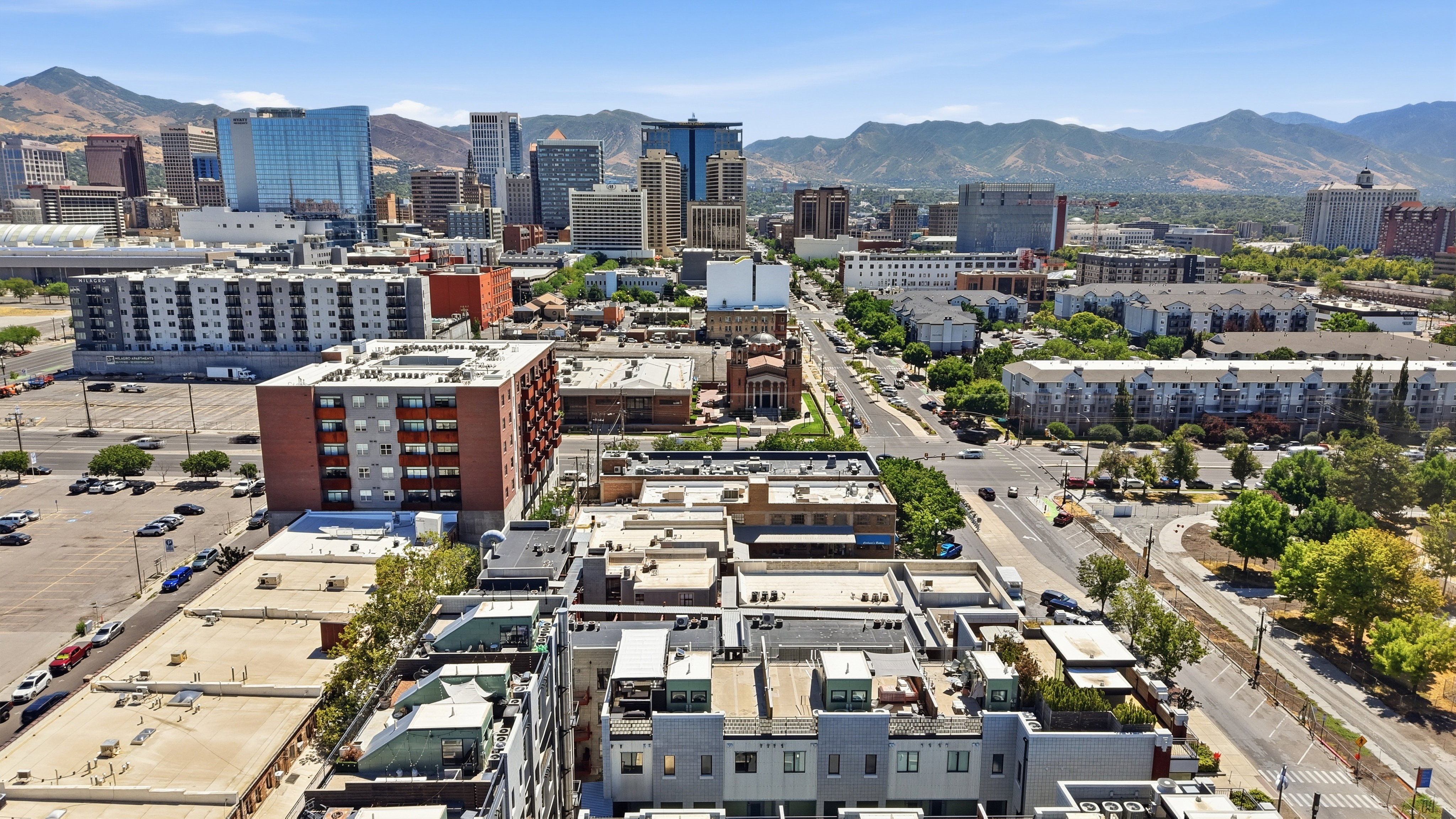 Expansive urban panorama featuring a diverse city skyline against a mountainous backdrop