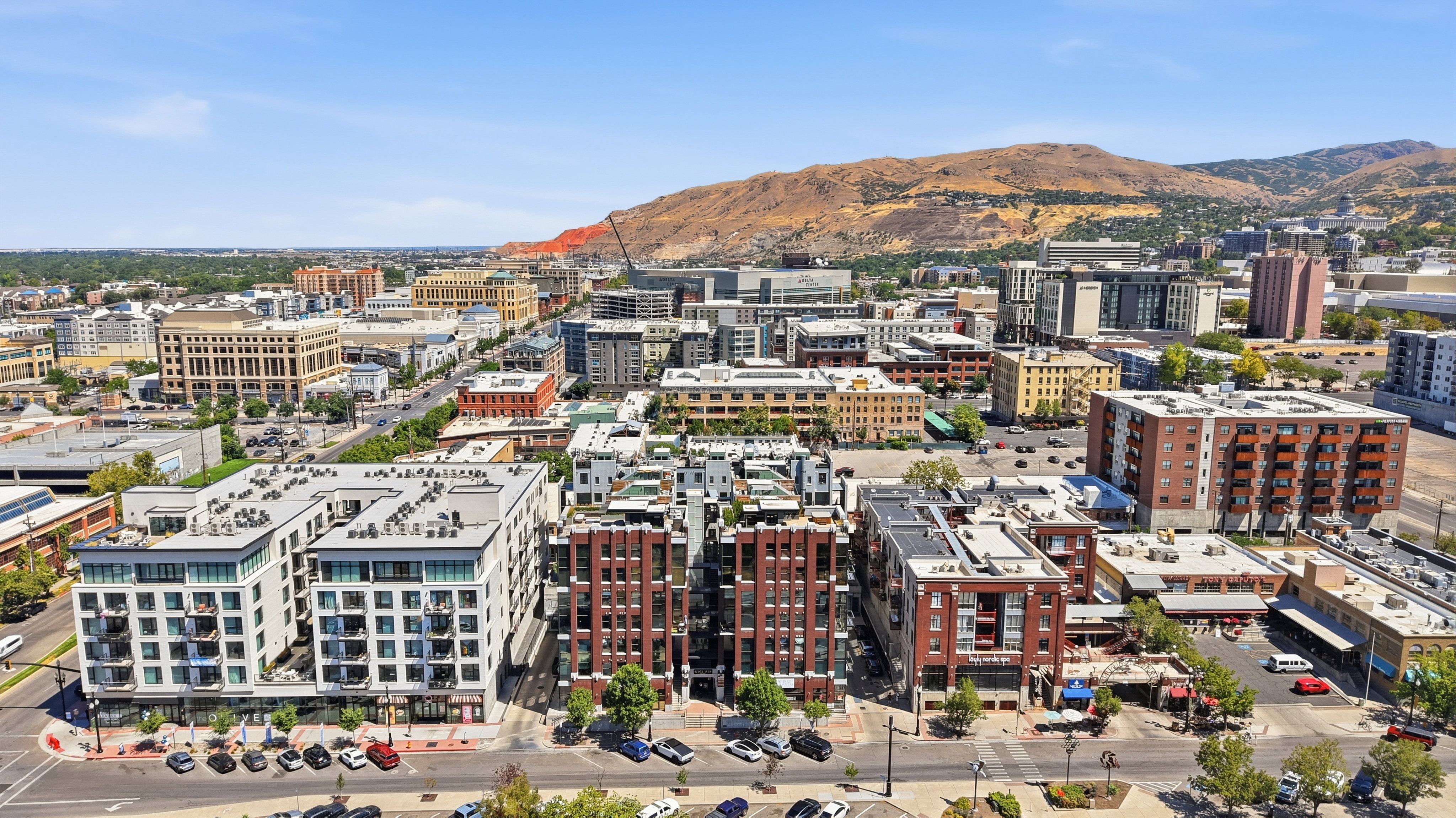 Expansive urban landscape featuring a mix of modern and traditional architecture, with a prominent mountainous backdrop