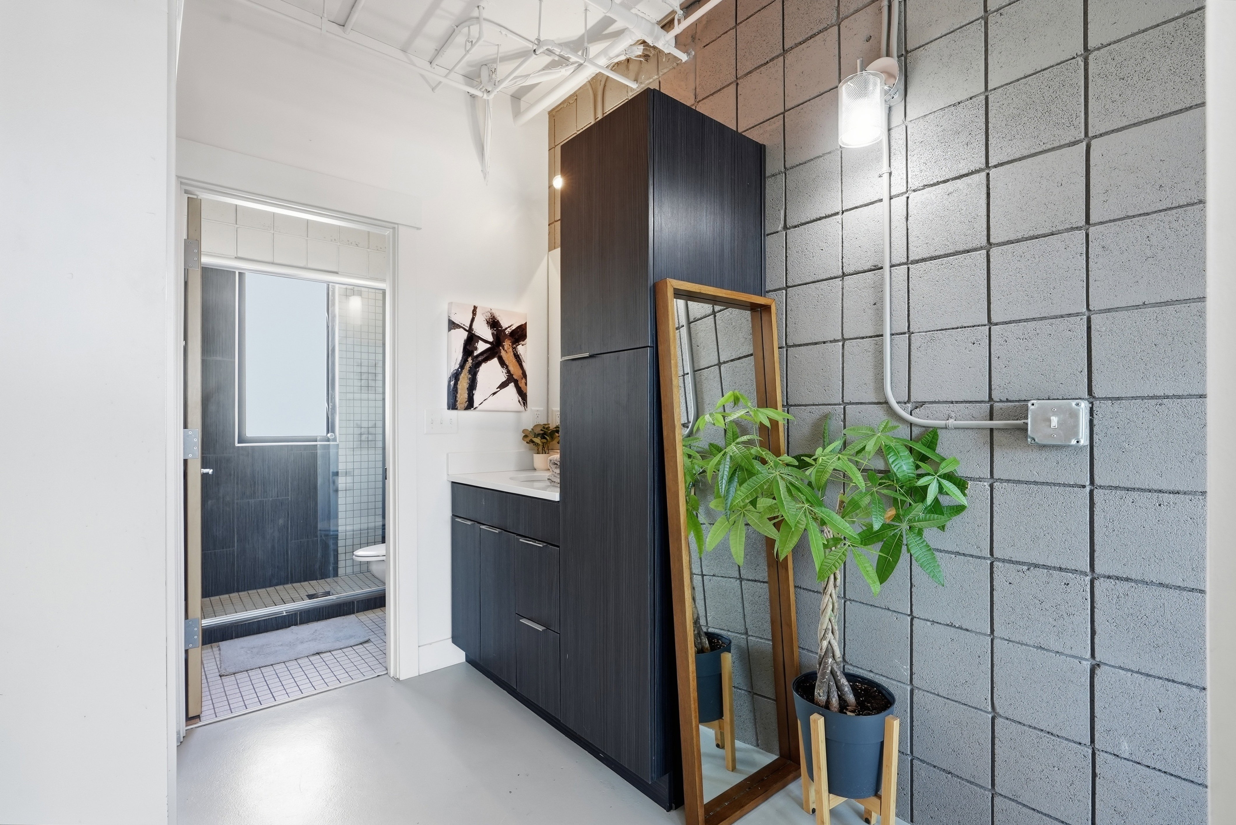Bathroom featuring a dark wood-finish vanity with a white countertop and contemporary hardware