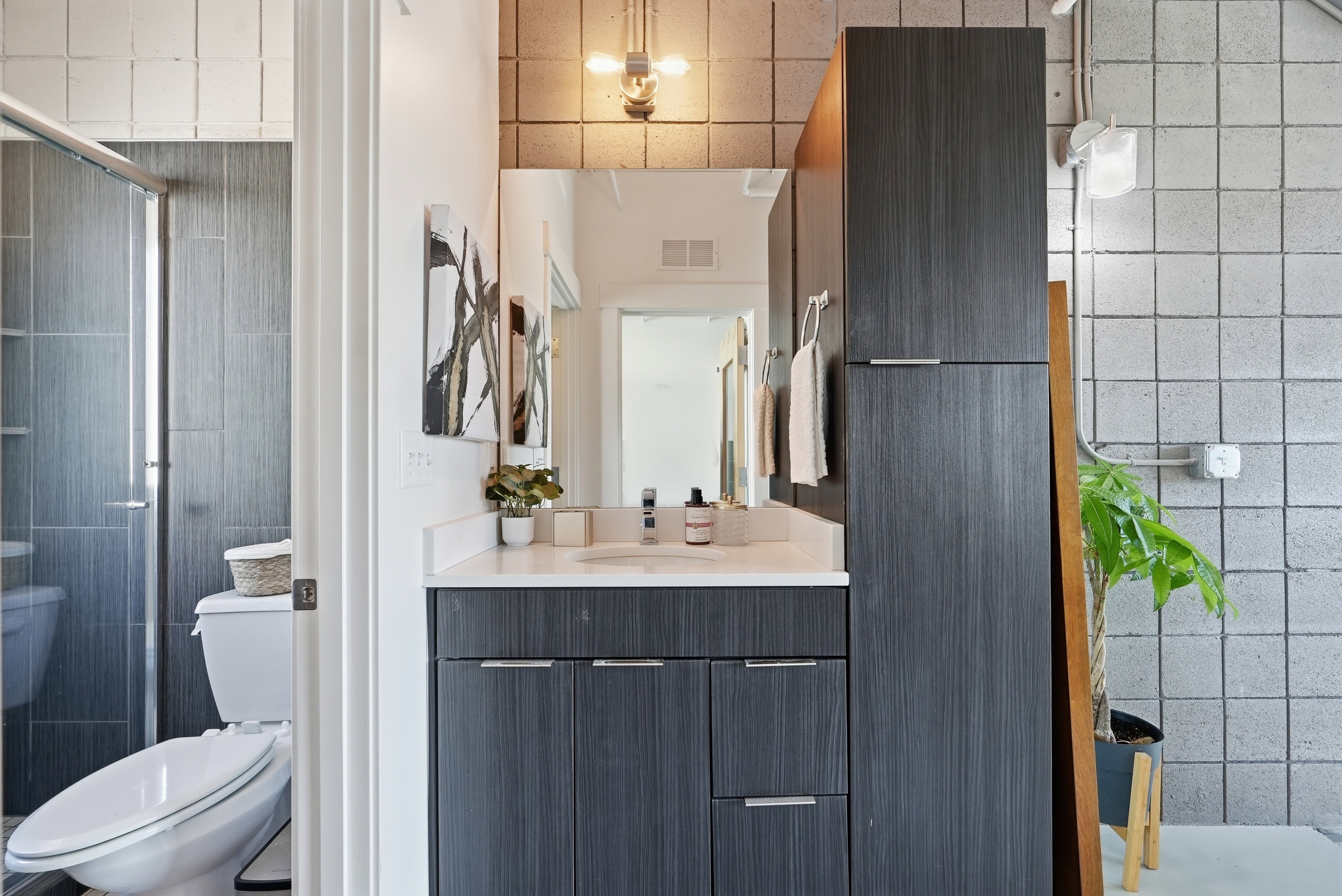 Contemporary bathroom featuring a dark wood-finish vanity with a white countertop and rectangular sink