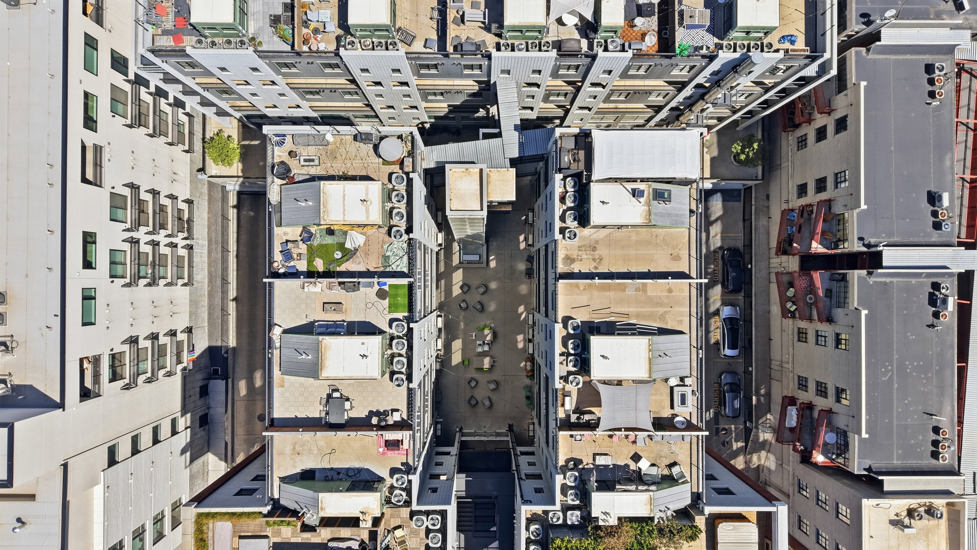 Modern urban residential complex featuring multiple buildings and diverse rooftop spaces