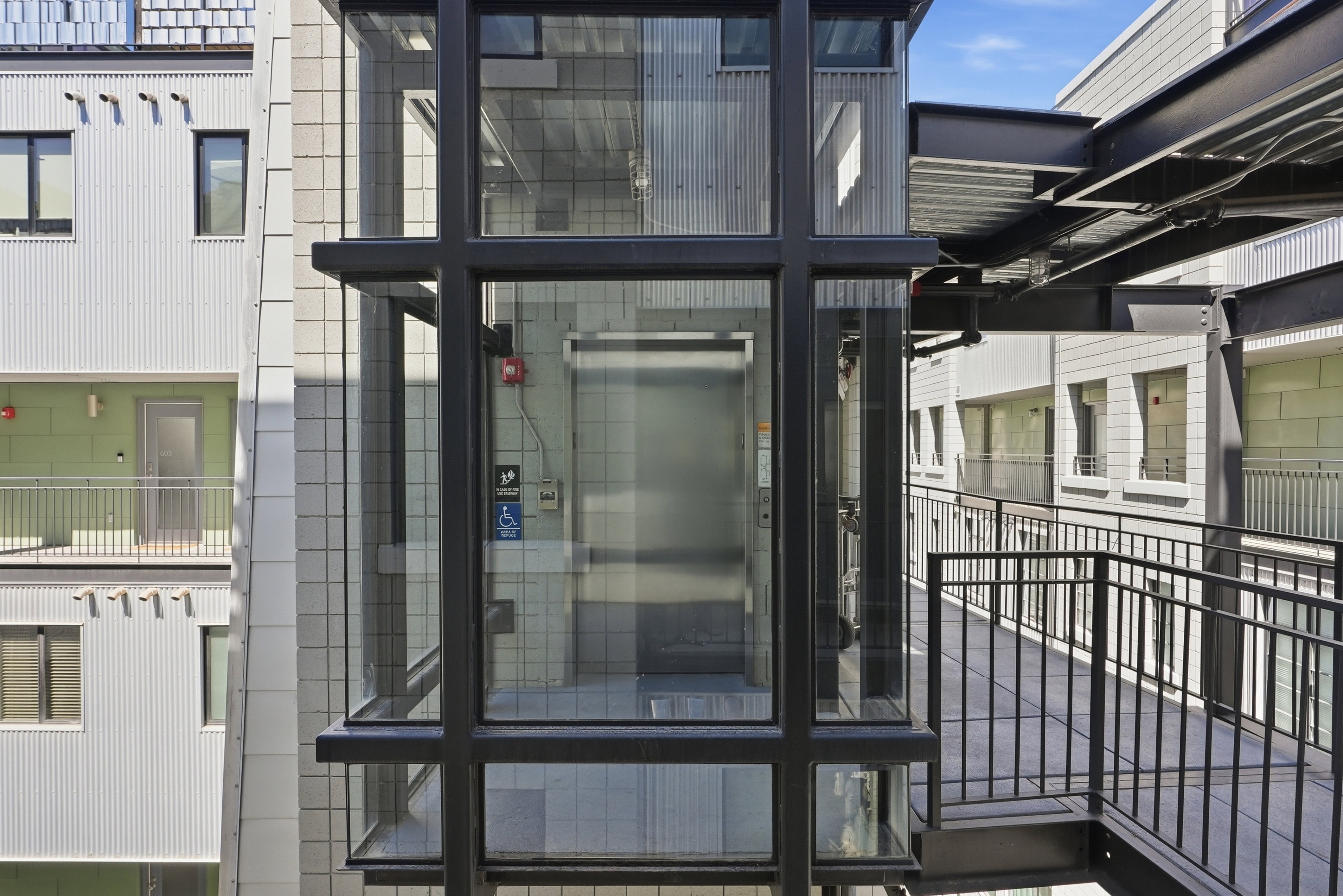 Modern glass-enclosed elevator with black framing