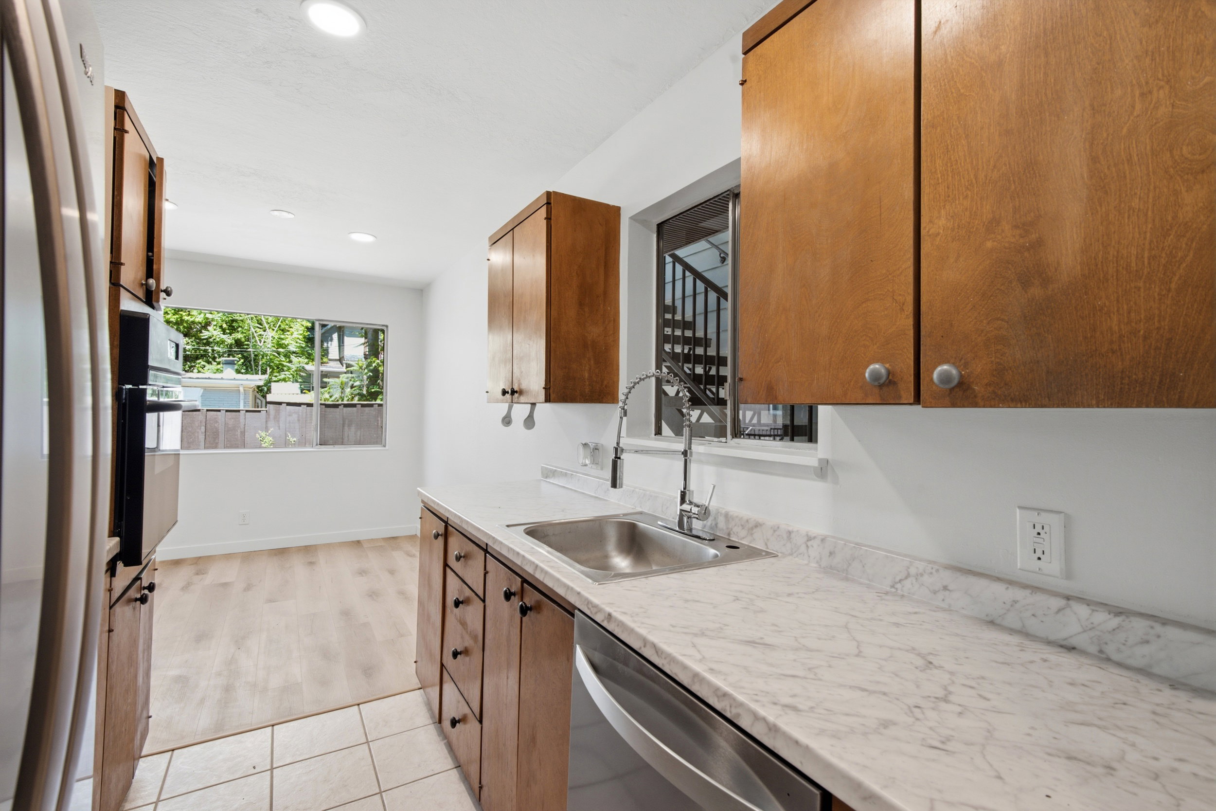 Kitchen featuring a stainless steel sink, pull-down faucet, and light-toned countertops