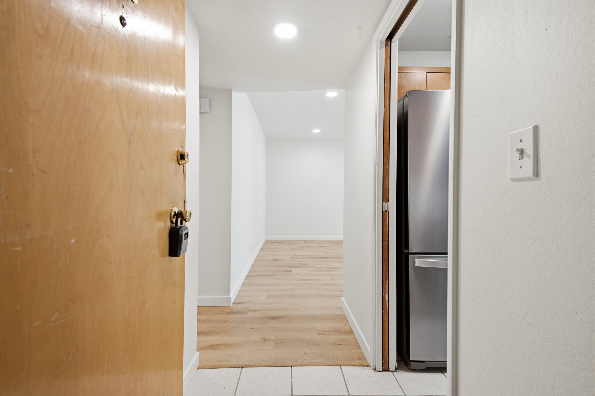 Entry foyer with light wood-finish flooring, recessed lighting, and white baseboards