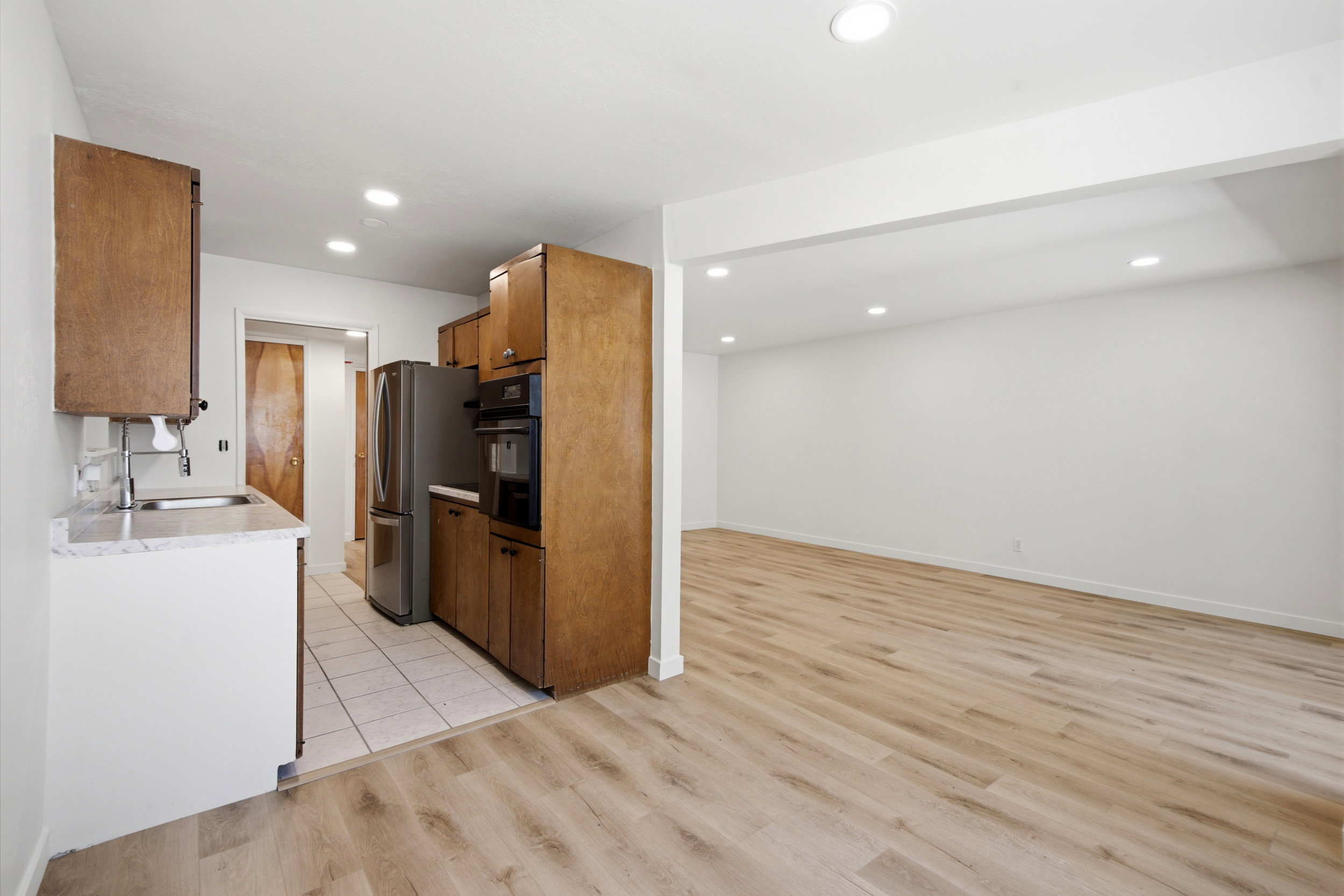 Open-concept living space featuring wood-finish flooring, recessed lighting, and a neutral wall palette