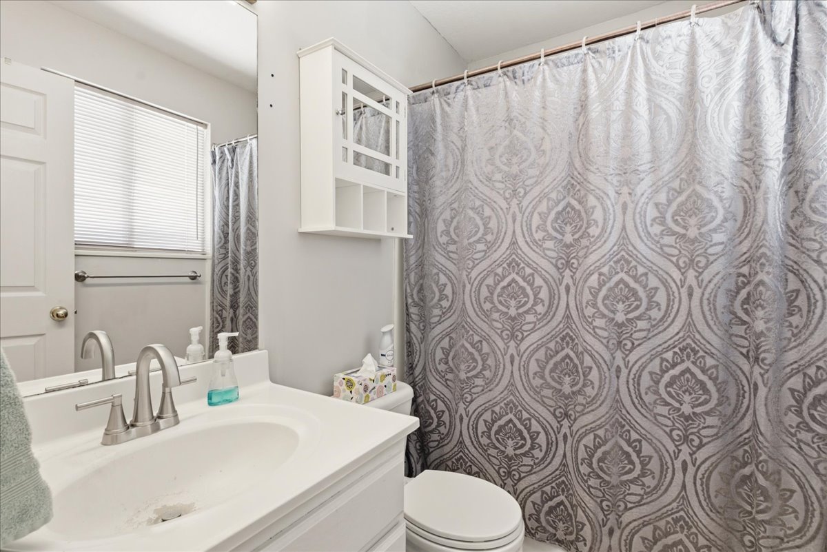 Bathroom vanity with a single basin sink and brushed nickel faucet