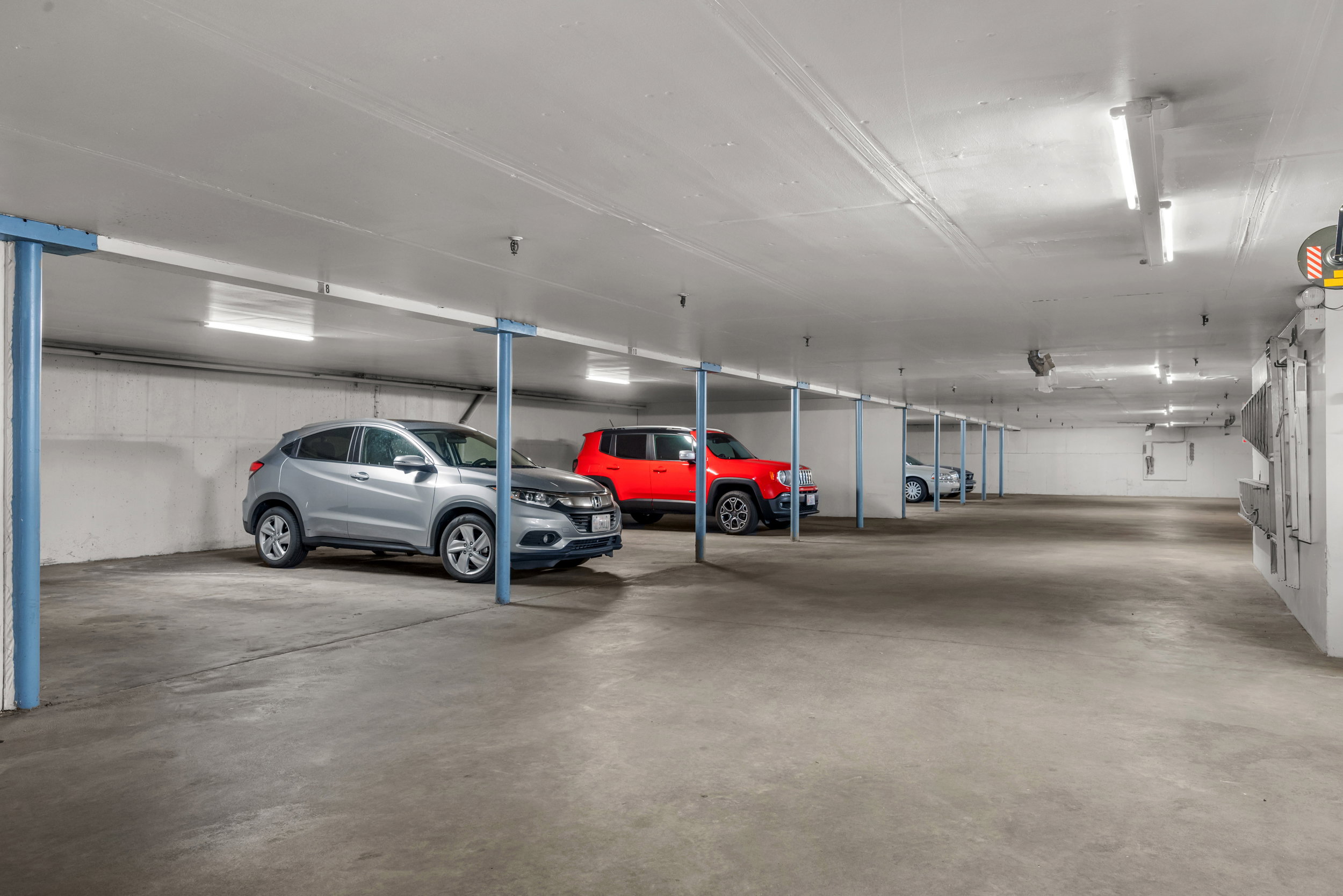 Spacious underground parking garage featuring concrete flooring and walls