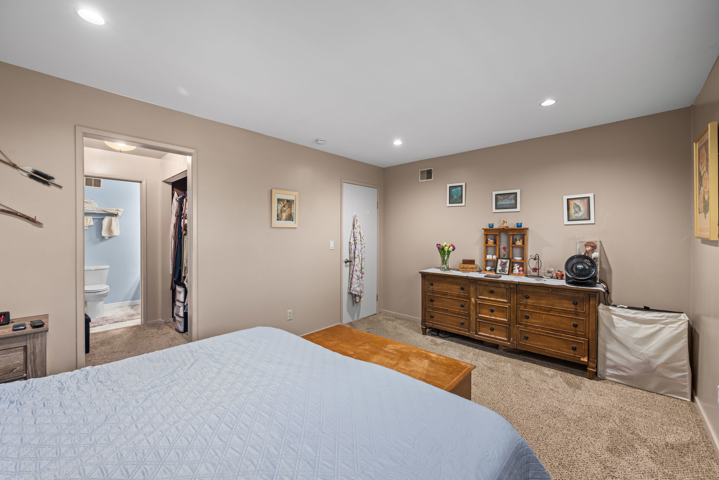 Carpeted bedroom with recessed lighting, offering a neutral color palette