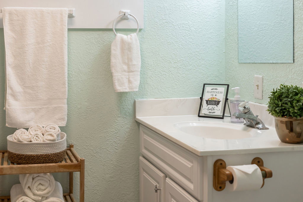 Bathroom vanity featuring a single basin sink, white countertop, and white cabinetry