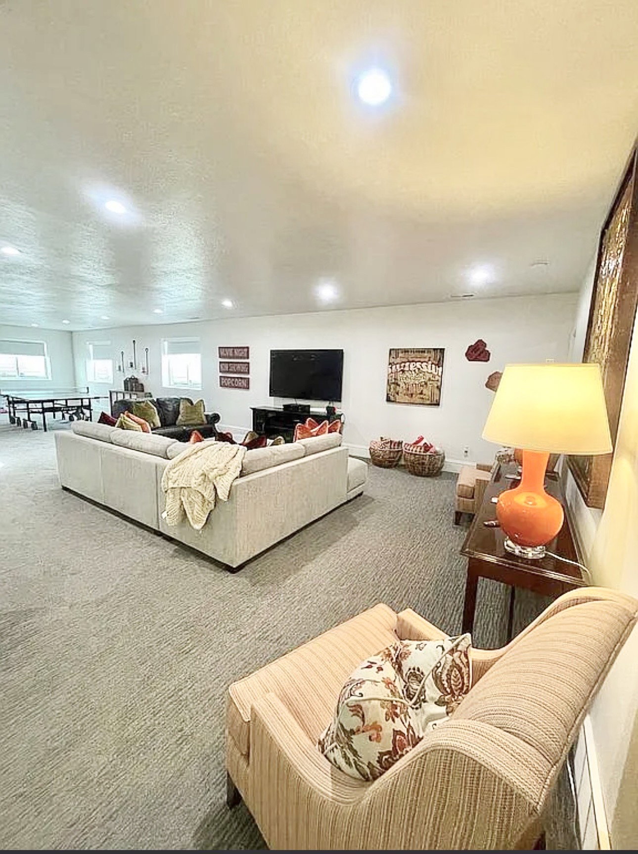 Spacious entertainment room featuring recessed lighting, light-toned carpeting, and multiple windows