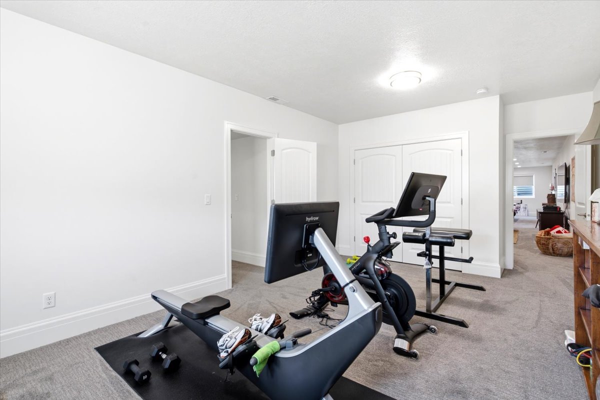 Spacious room with light gray carpeting and white painted walls