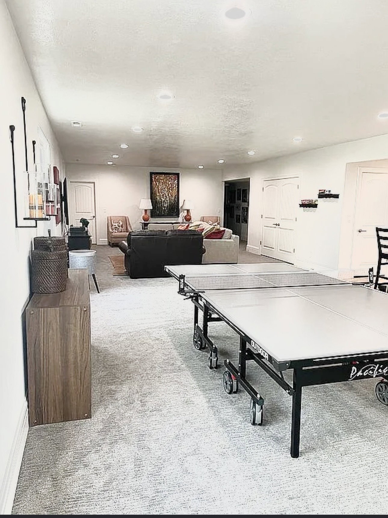 Spacious entertainment area with recessed lighting, light-toned walls, and a patterned carpet