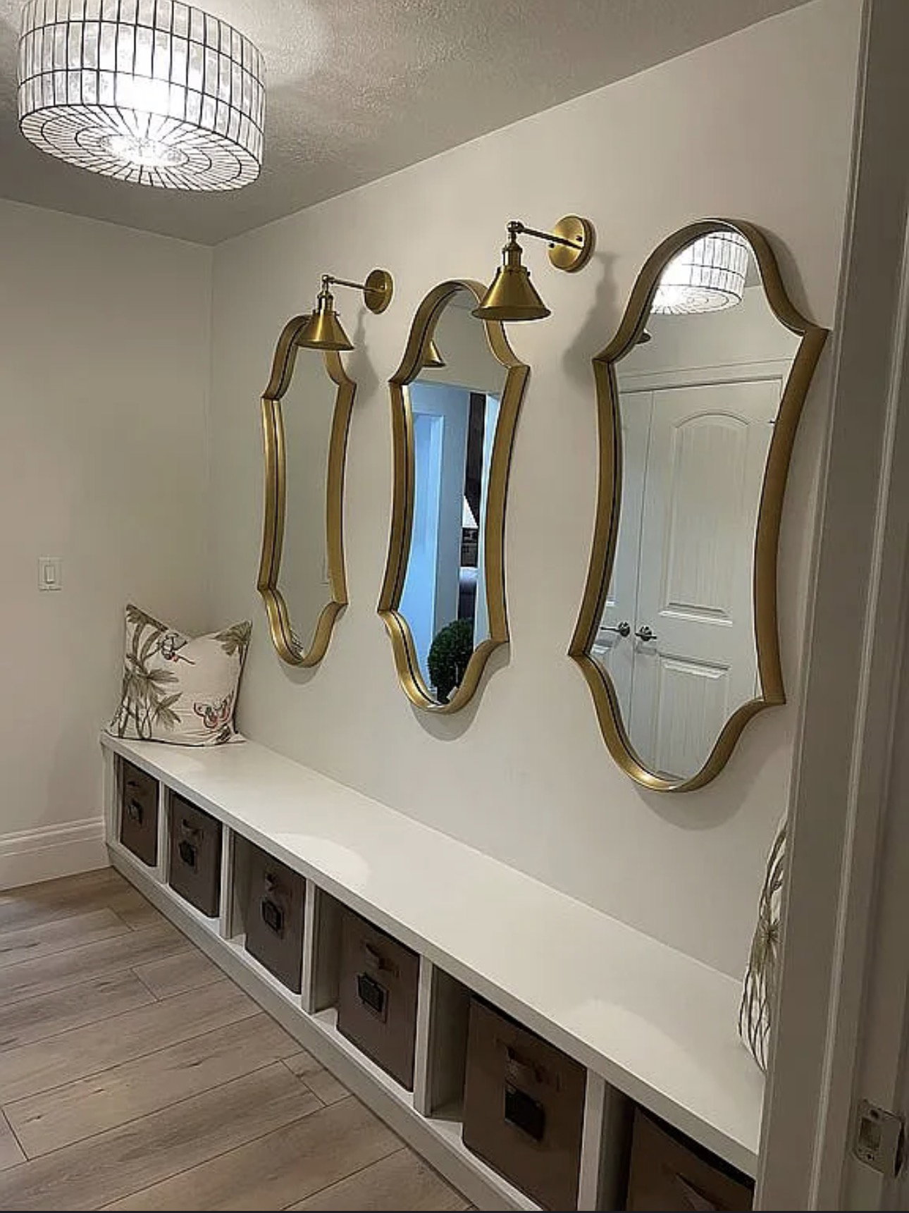 Built-in hallway bench with open cubby storage, wood-finish flooring, and a decorative ceiling fixture