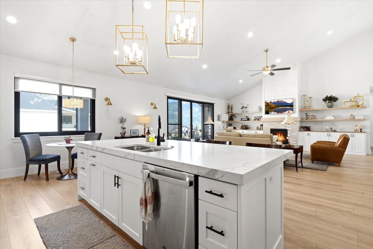 Expansive kitchen island with a stone-finish countertop, undermount sink, and integrated dishwasher