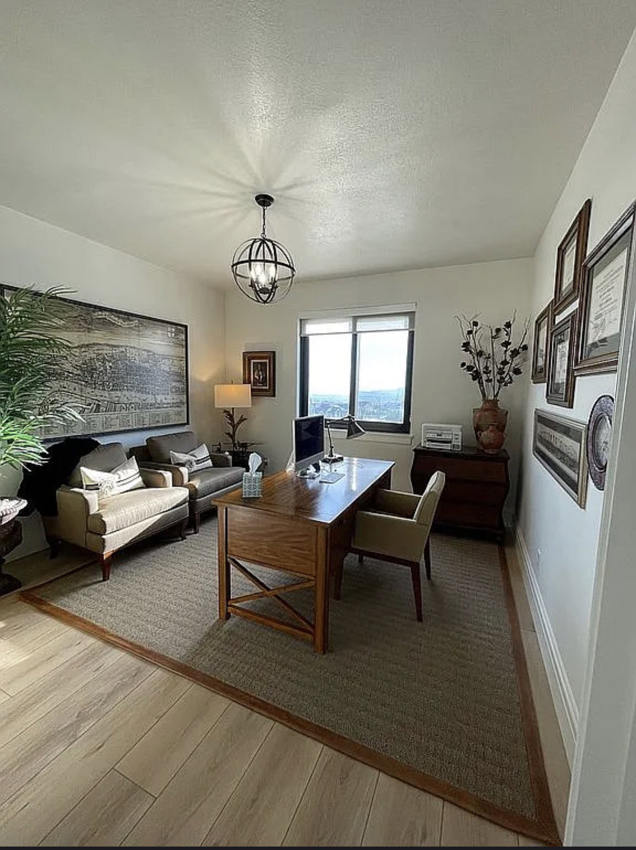 Dedicated interior space featuring wood-finish flooring, a built-in window with a roller shade, and a spherical chandelier