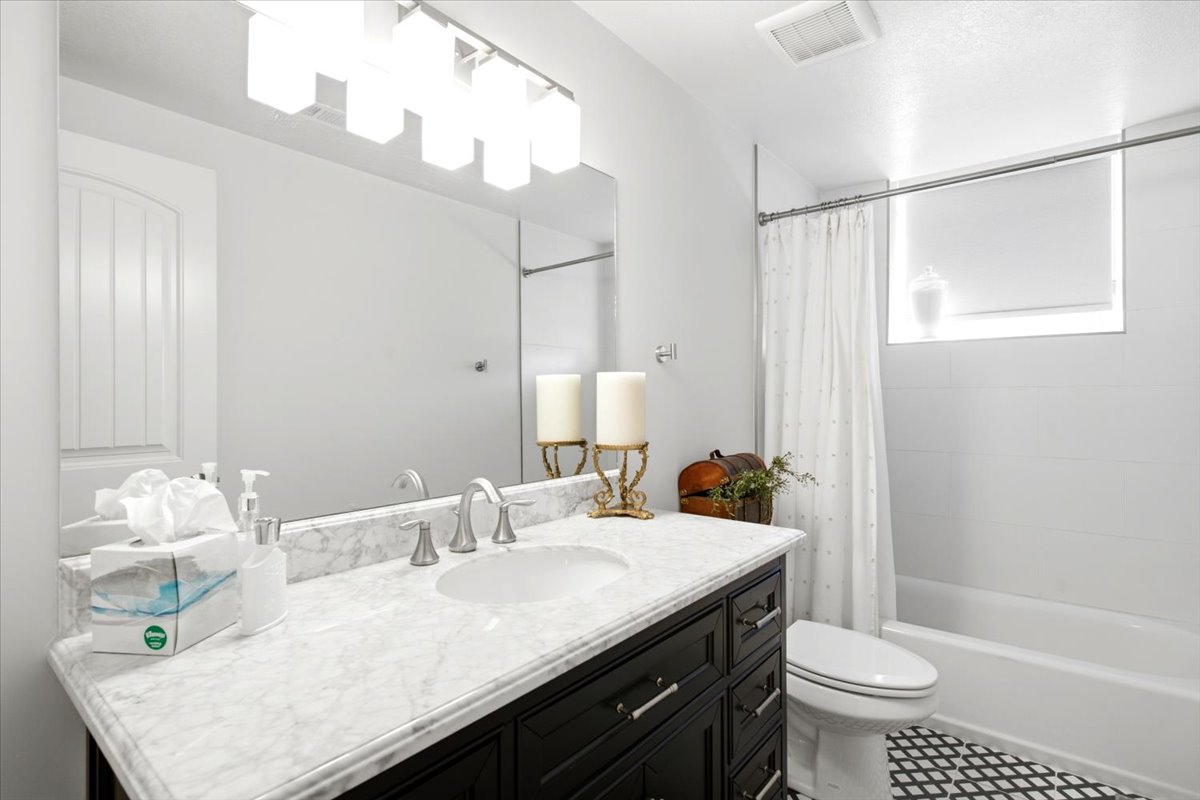 Bathroom with a black vanity featuring a white countertop and an undermount sink