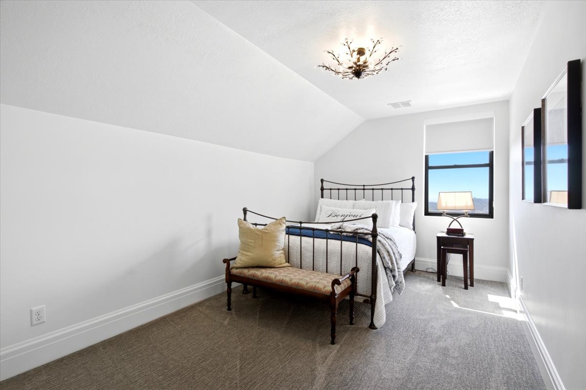 Room featuring sloped ceiling, light gray carpet flooring, and white baseboards