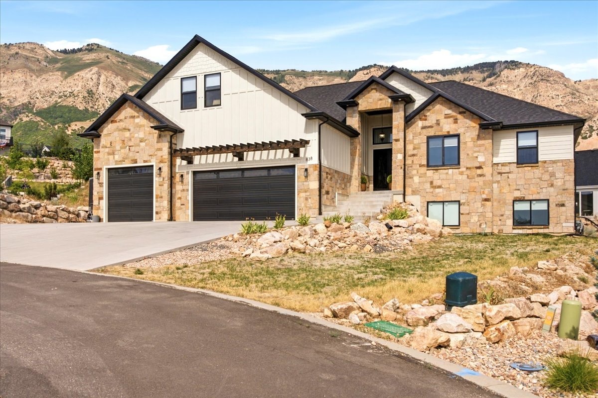 Contemporary residence featuring a stone facade, board and batten siding, and a prominent front entry with a covered porch