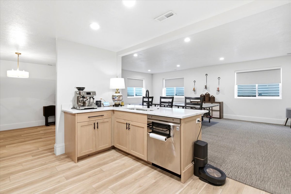 L-shaped kitchen island featuring light wood-finish cabinetry and a light-toned countertop