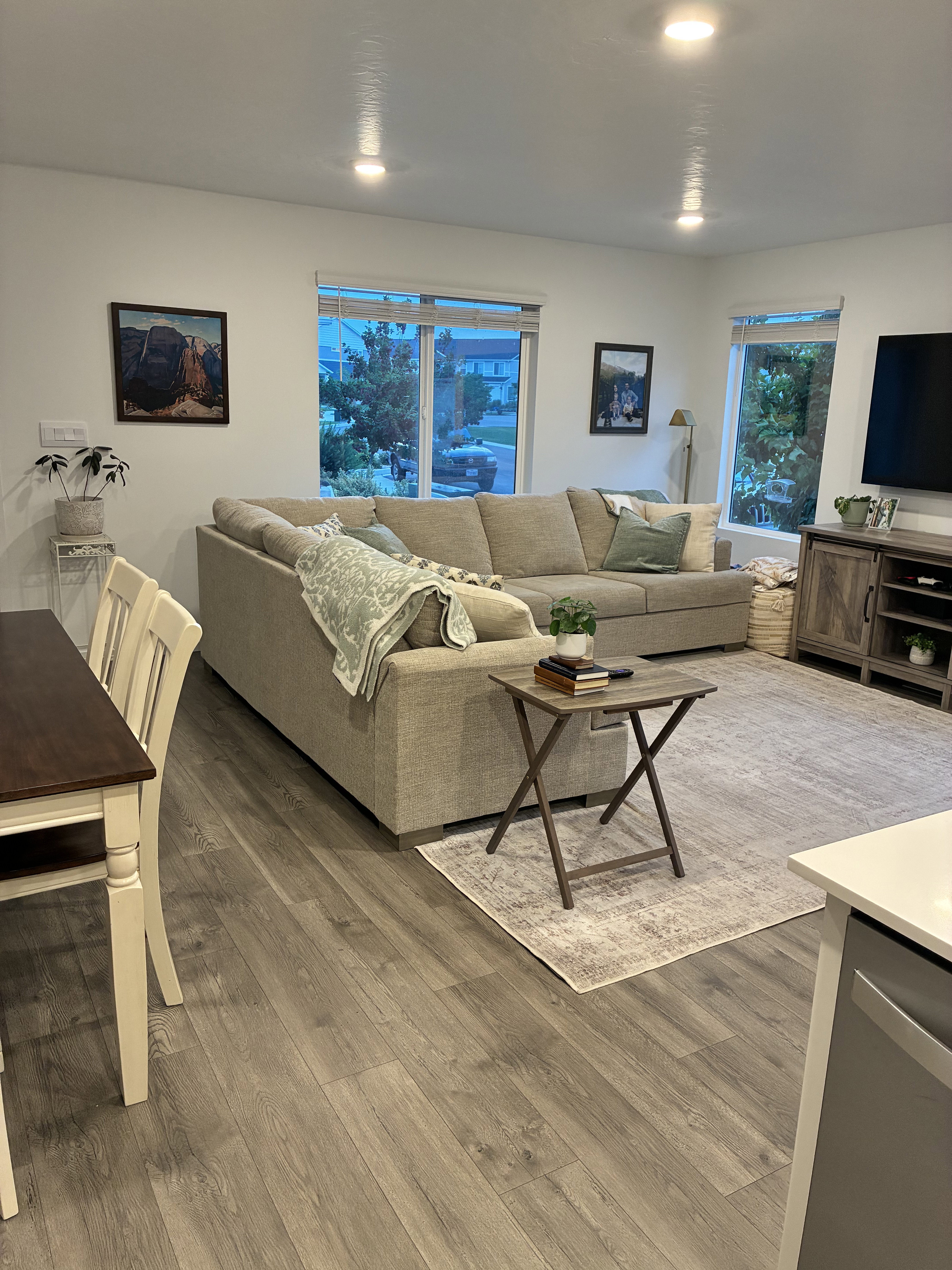 Open-concept living area featuring wood-finish flooring, recessed ceiling lighting, and multiple windows
