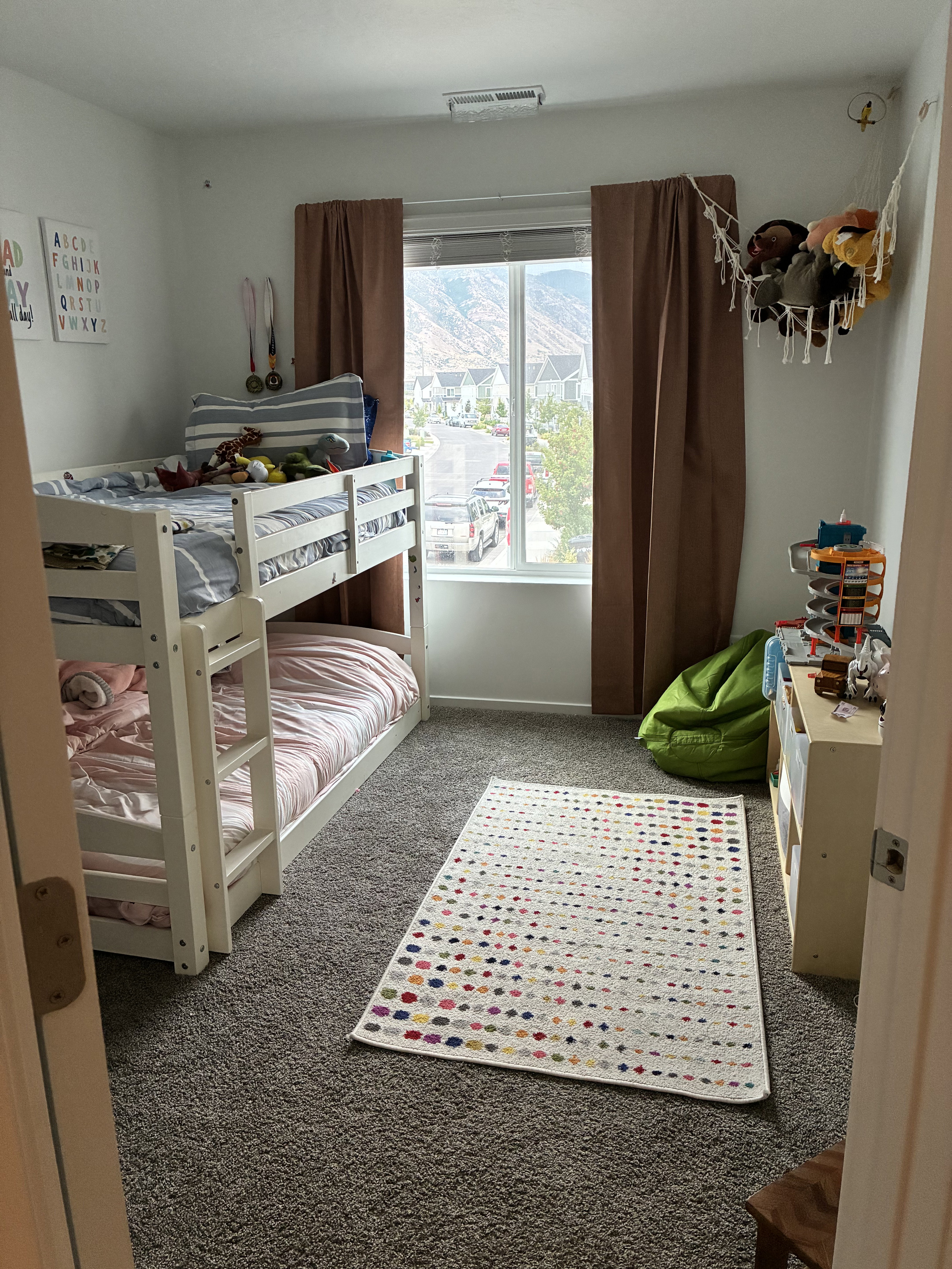 Carpeted room with a large window, offering distant mountain scenery