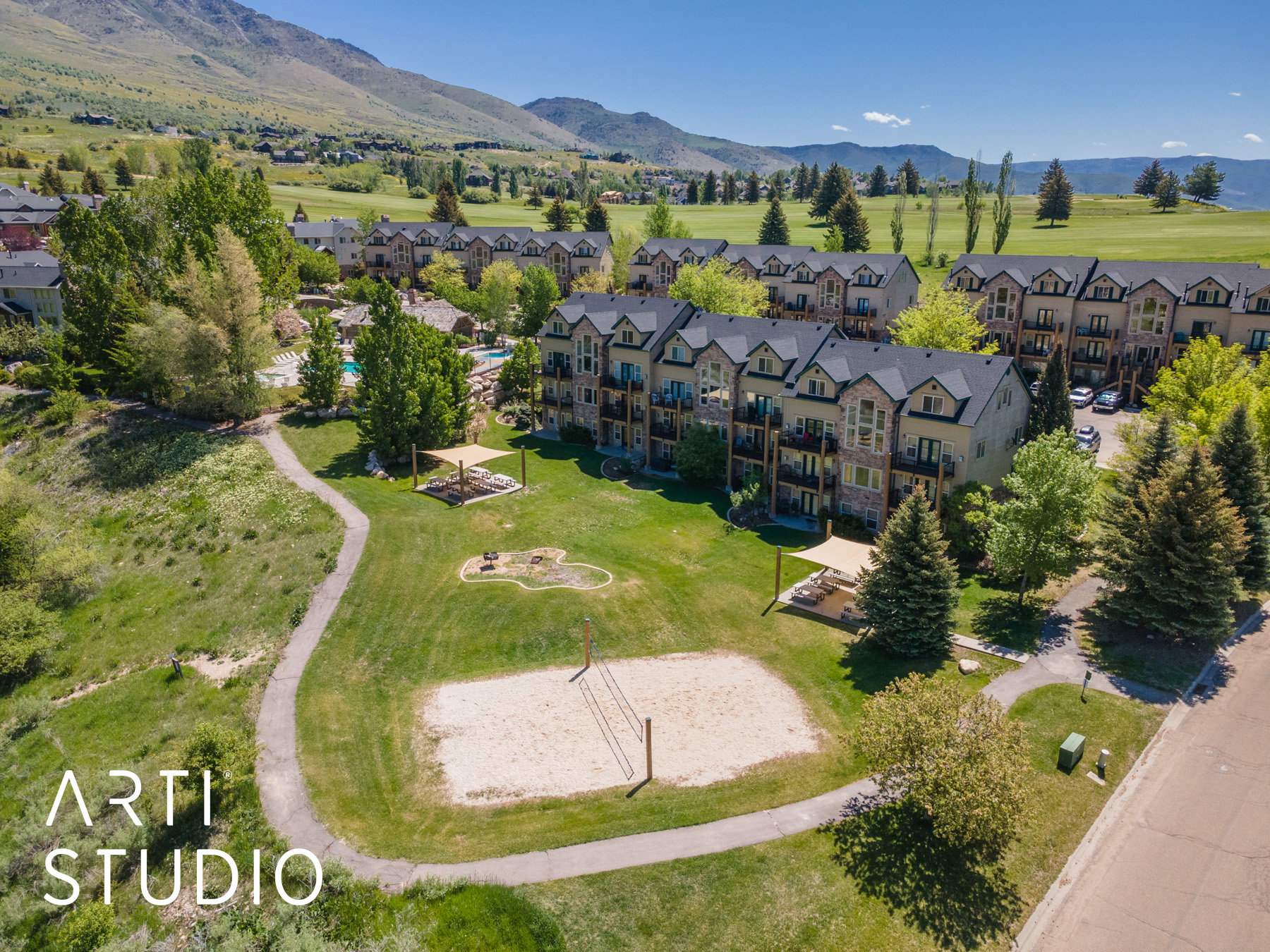 Community featuring a sand volleyball court, walking paths, picnic area, expansive green spaces, and mature landscaping