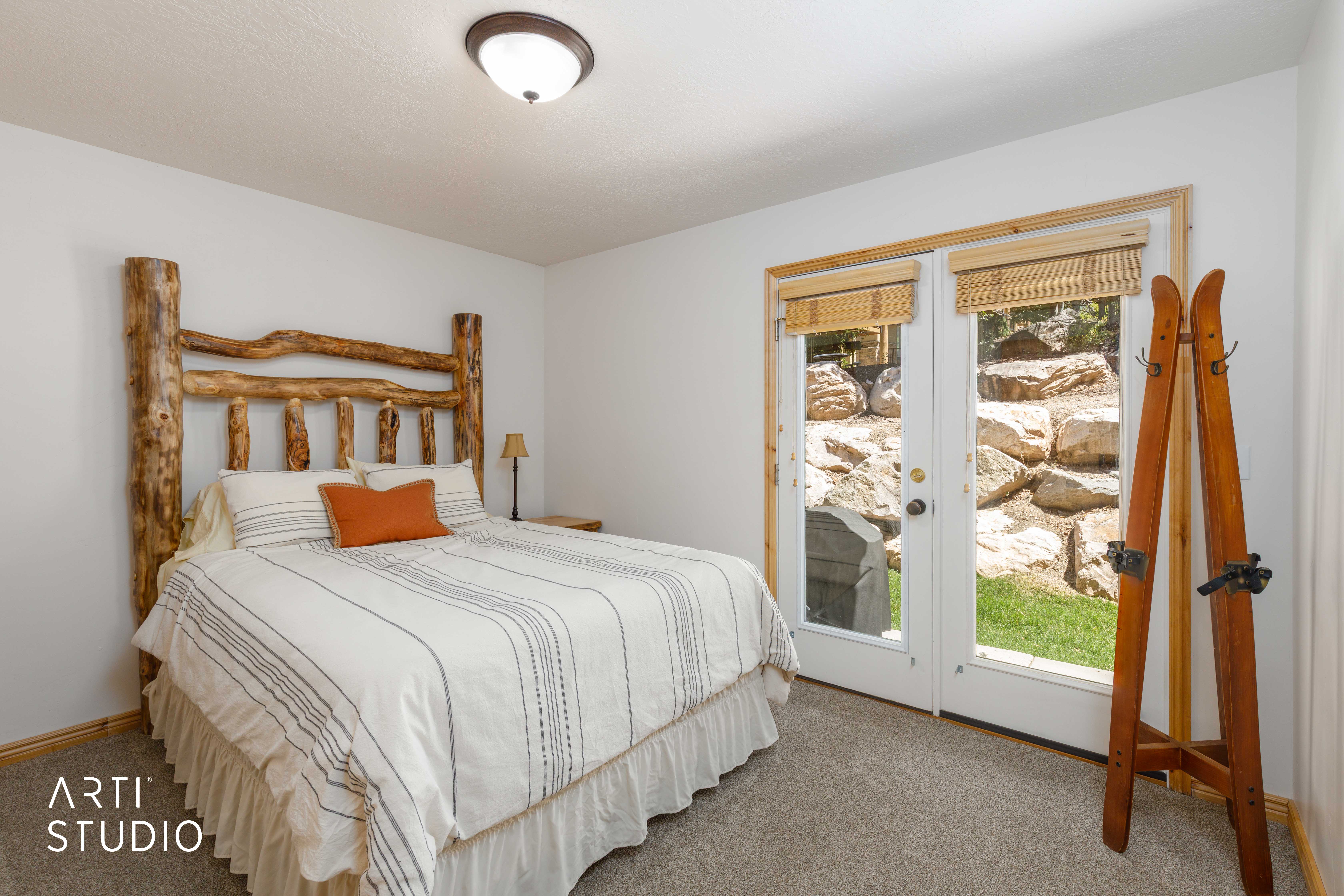 French doors with wood-finish trim and integrated shades open to outdoor patio  with Grill and deck space.