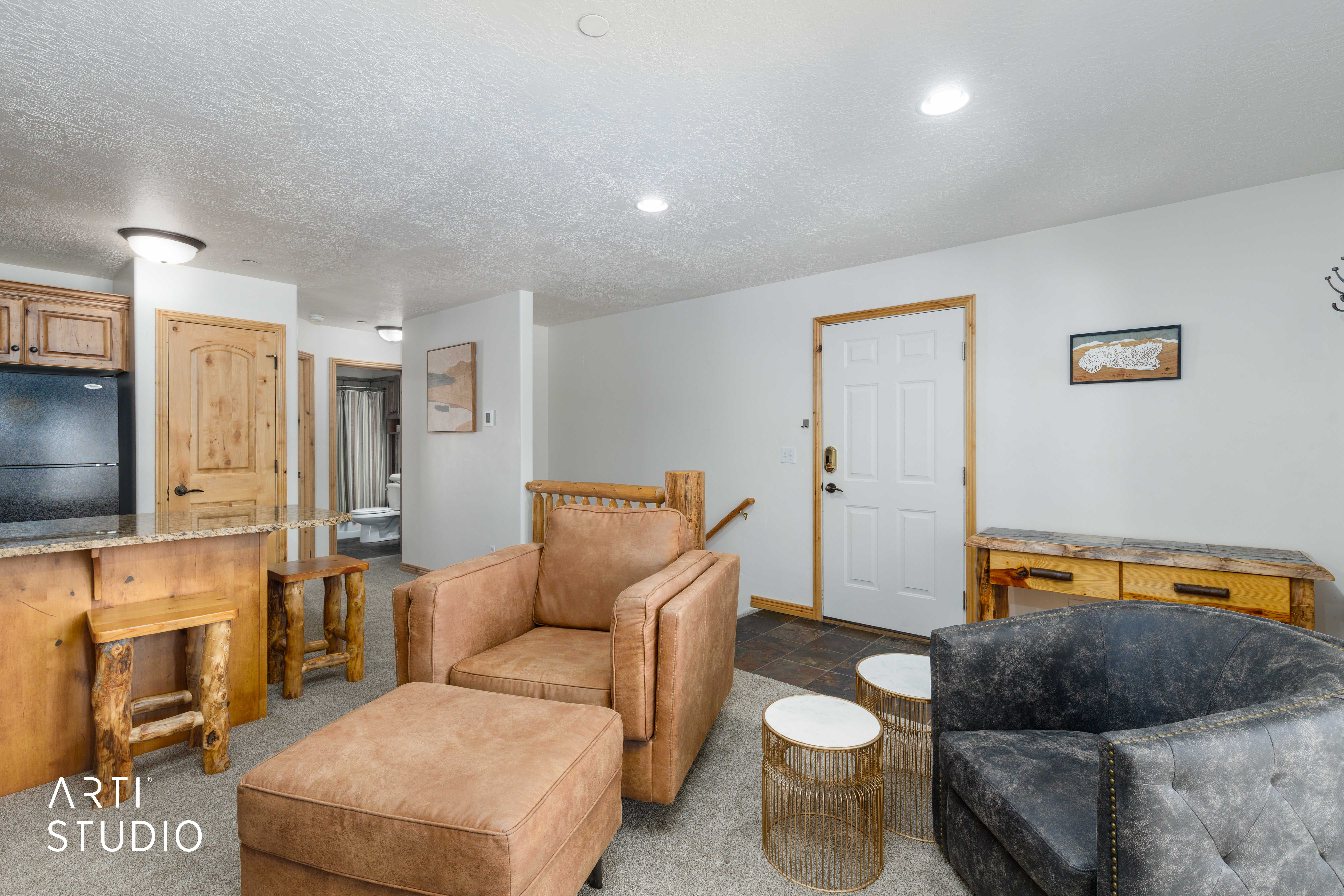 Open-concept living space featuring a breakfast bar with granite-look countertops, warm wood-finish cabinetry, and recessed lighting