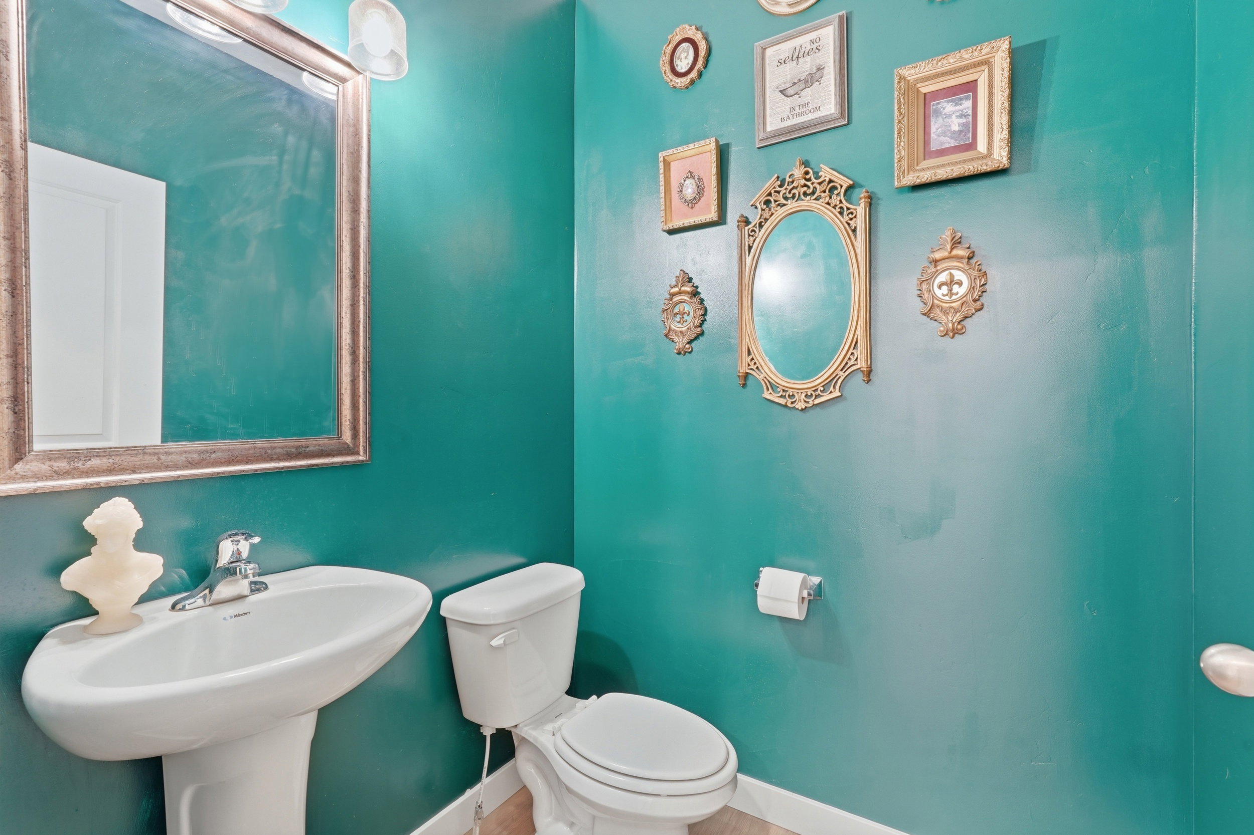 Pedestal sink with chrome faucet, complemented by a commode