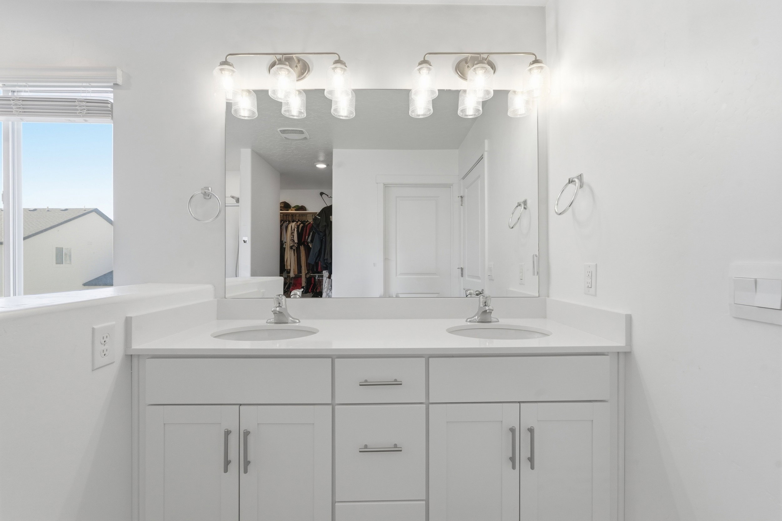 Double vanity featuring white cabinetry, undermount sinks, and a light-toned countertop