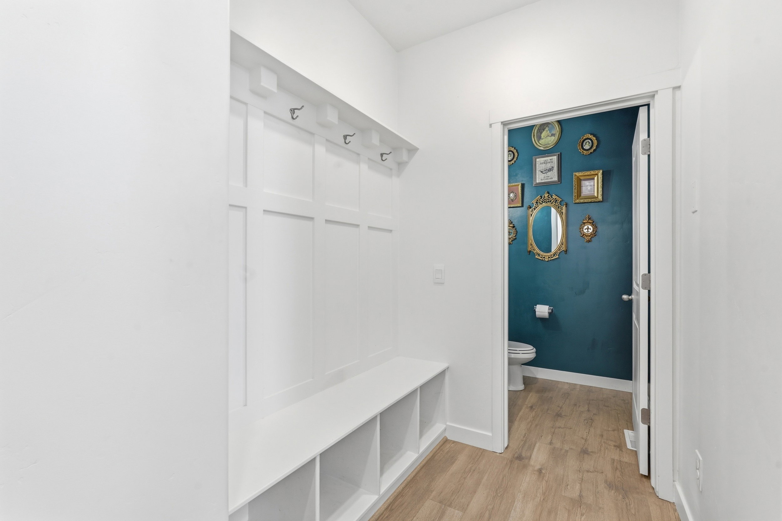 Entryway featuring a built-in bench with integrated cubbies and wall-mounted coat hooks